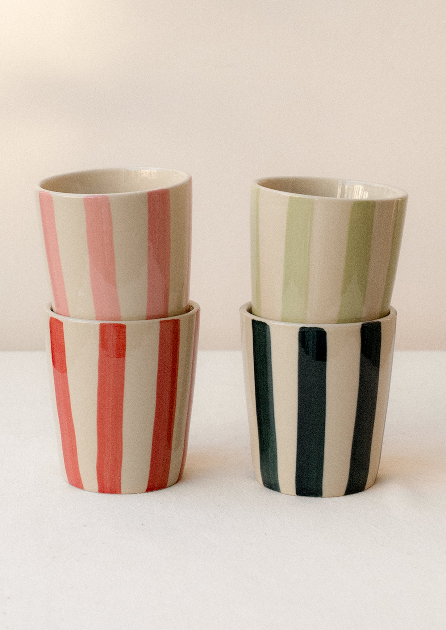 A stack of striped ceramic tumblers in assorted colors.