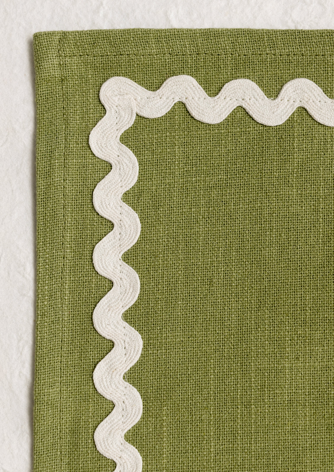 A moss green table runner with white ricrac border.