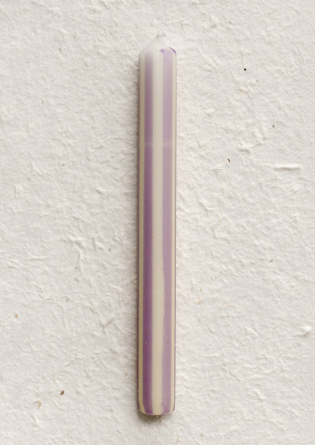 A pinstripe patterned candle in ivory and lavender stripes.