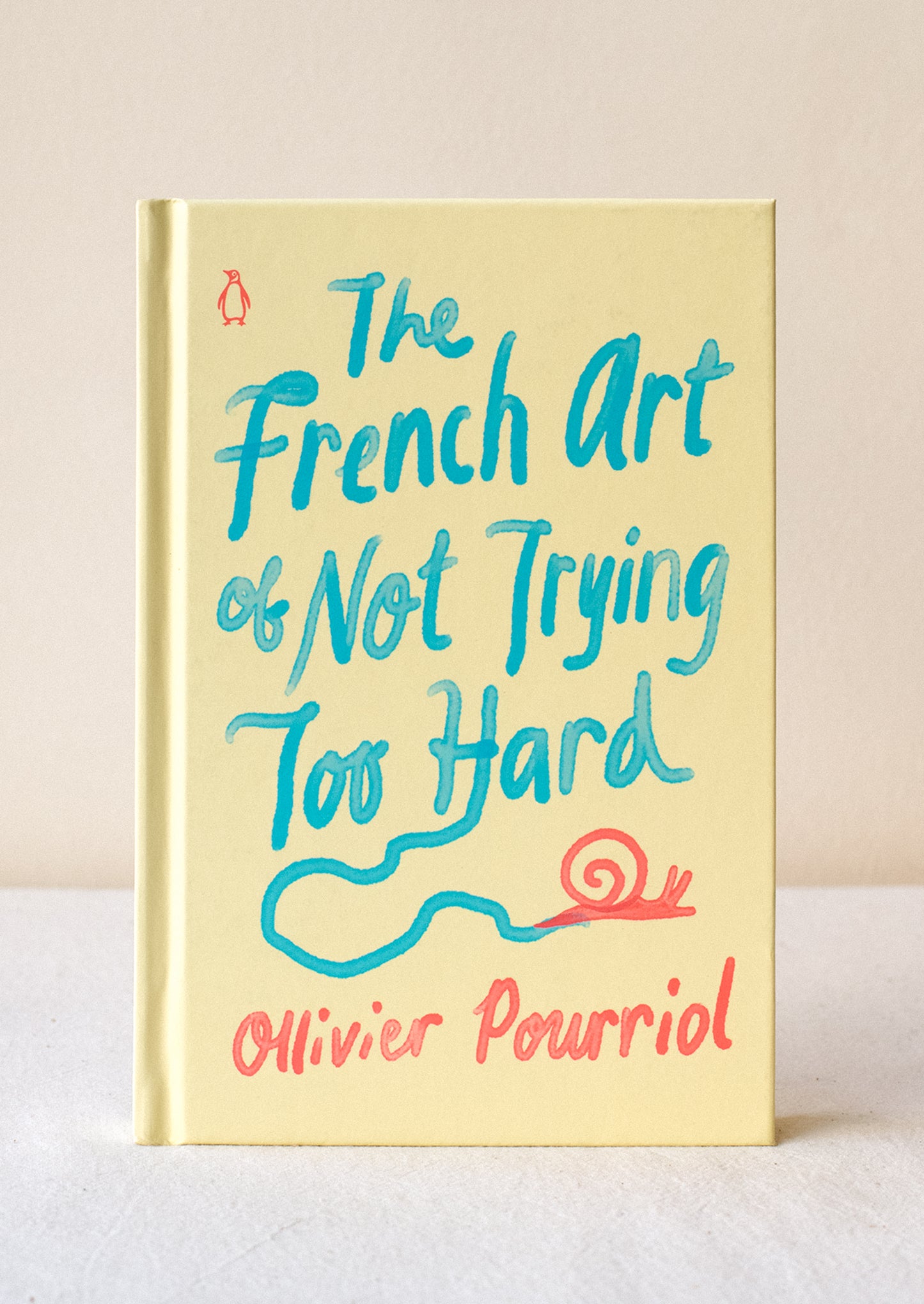 A pale yellow hardcover book titled "The French Art Of Not Trying Too Hard".