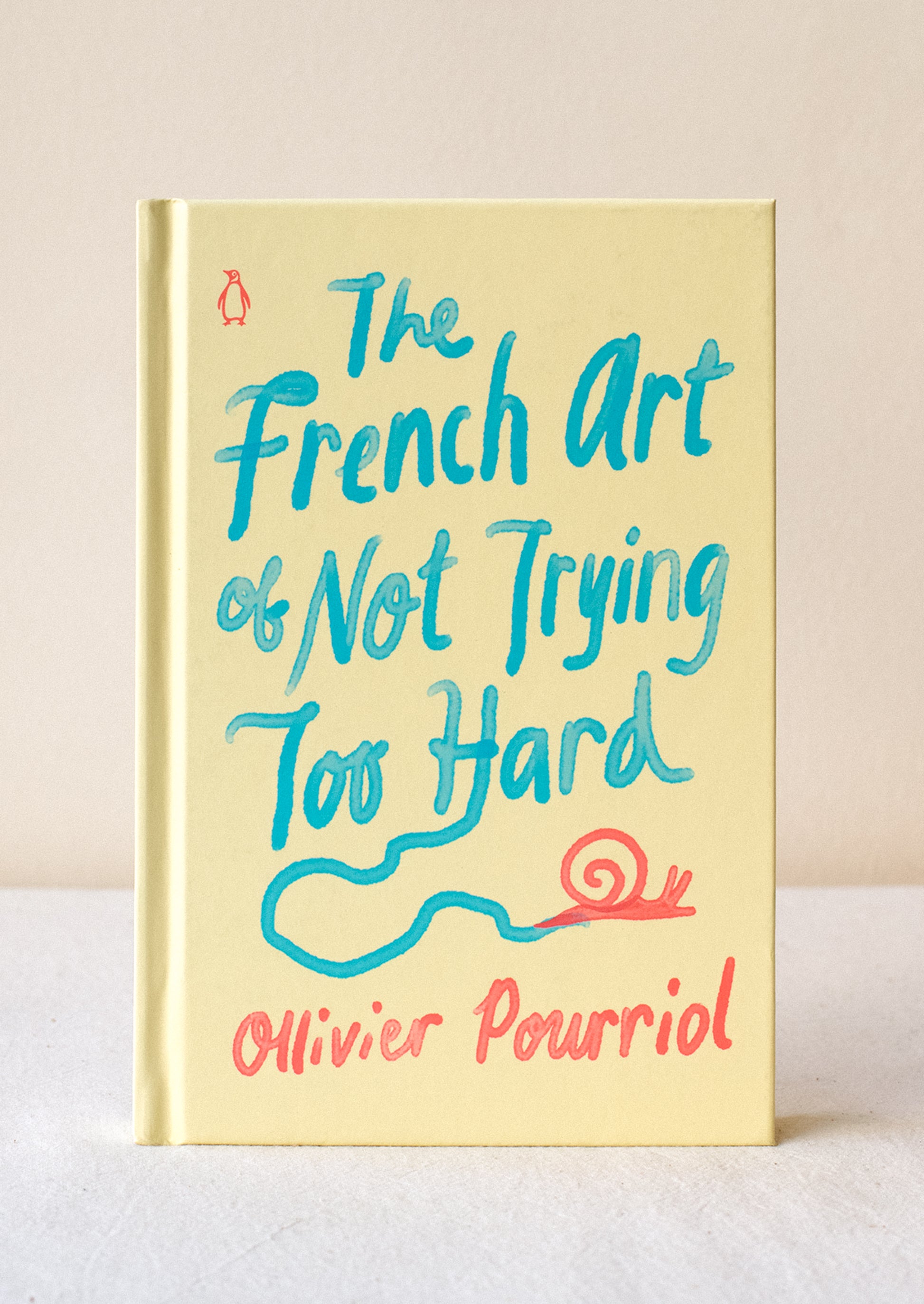 A pale yellow hardcover book titled "The French Art Of Not Trying Too Hard".