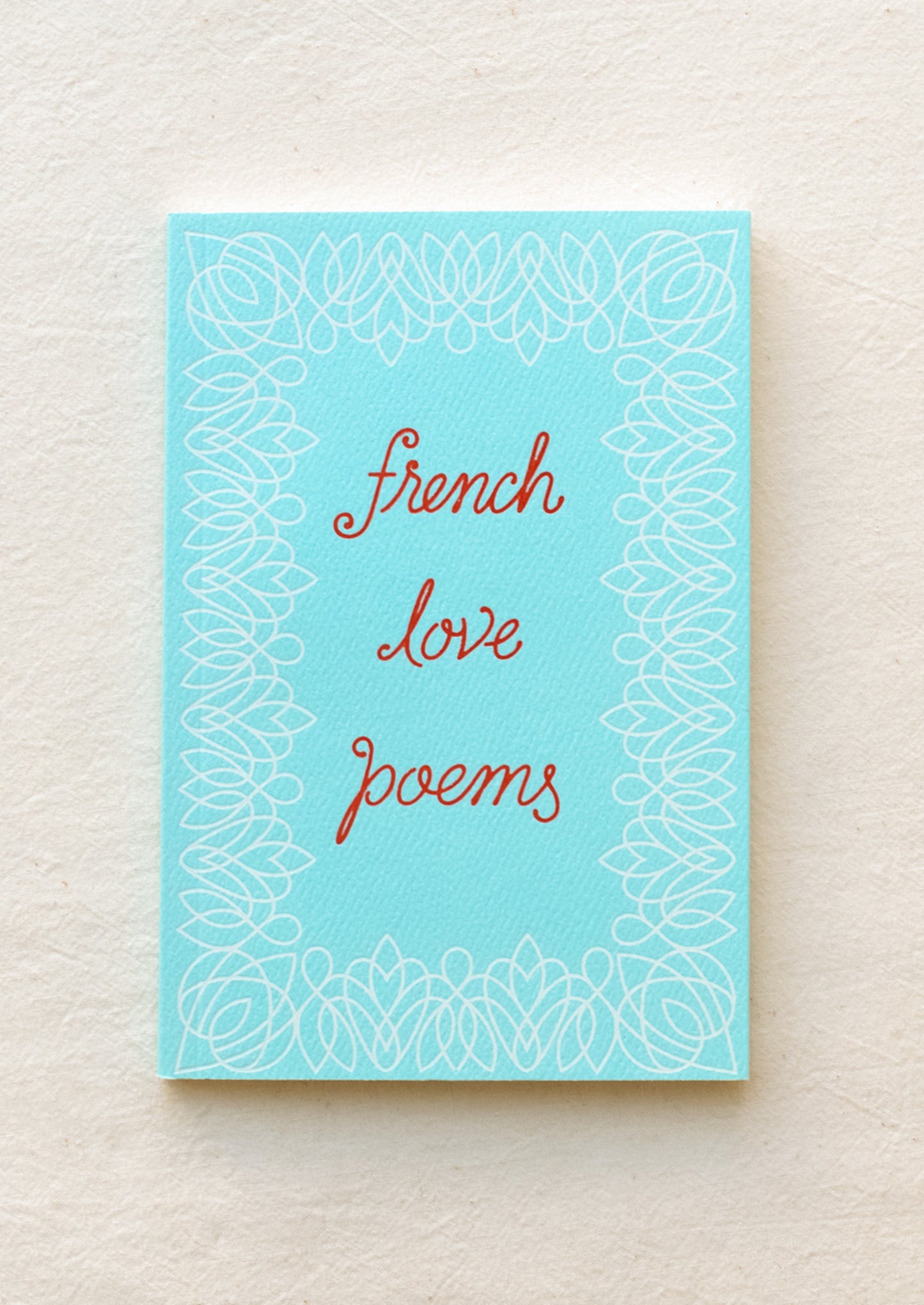 Small blue book with red writing featuring the text "french love poems".