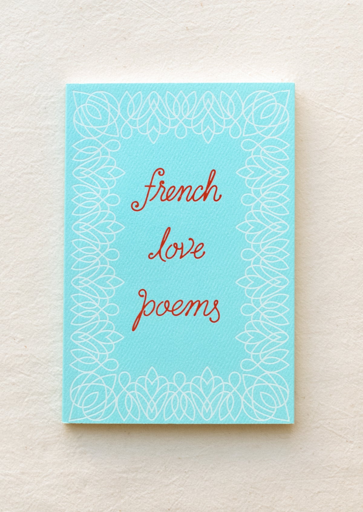 Small blue book with red writing featuring the text "french love poems".