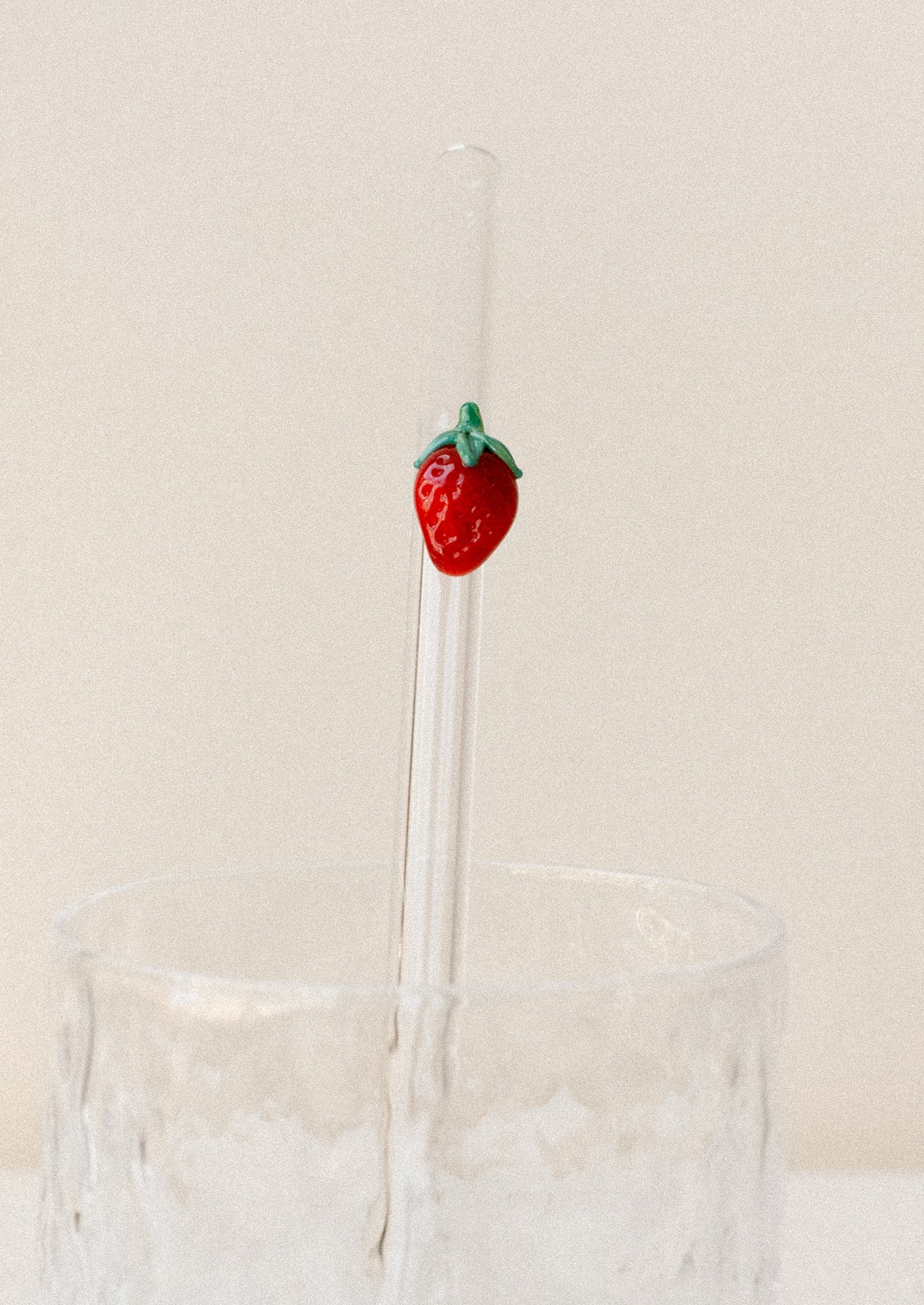 A clear glass straws with bent shape, with lampwork strawberry figurine.