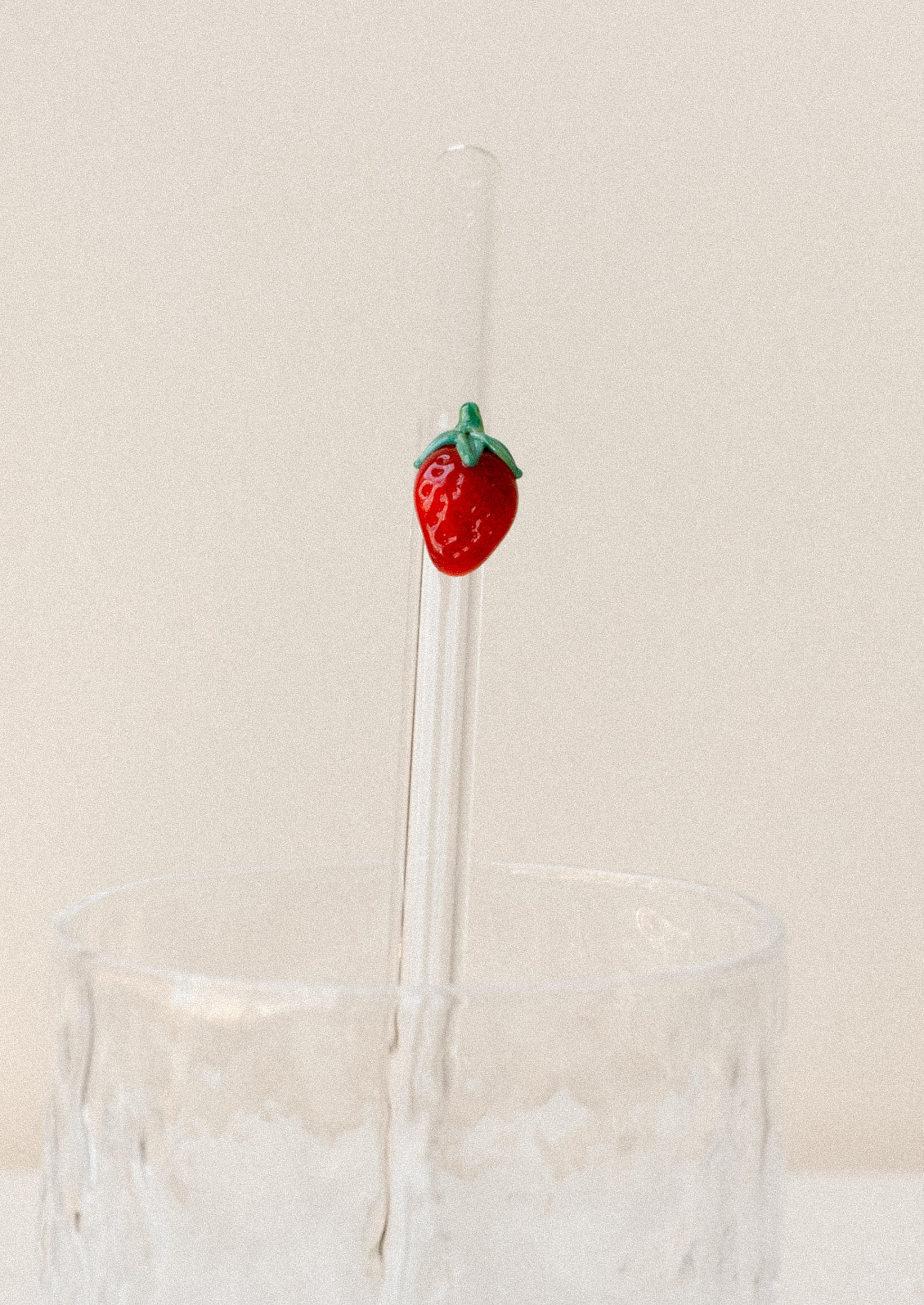 A clear glass straws with bent shape, with lampwork strawberry figurine.