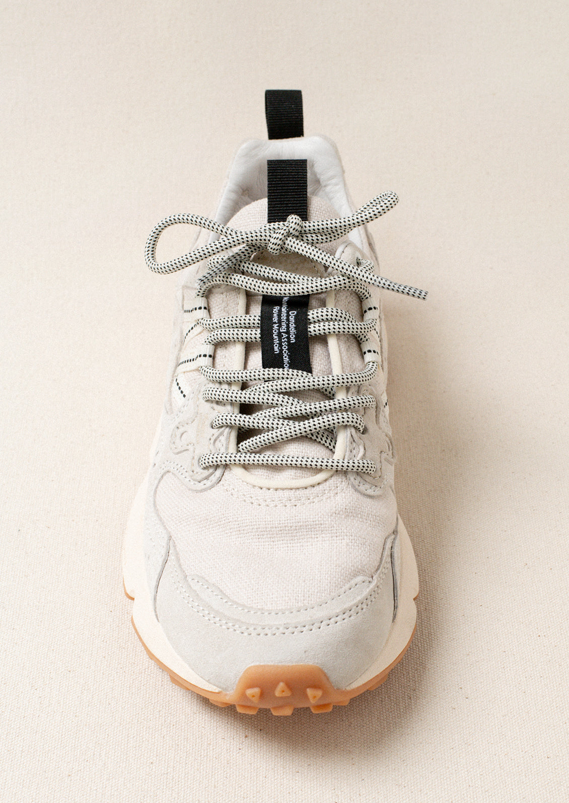 A pair of sporty sneakers in neutral colors with flower cutout detailing.