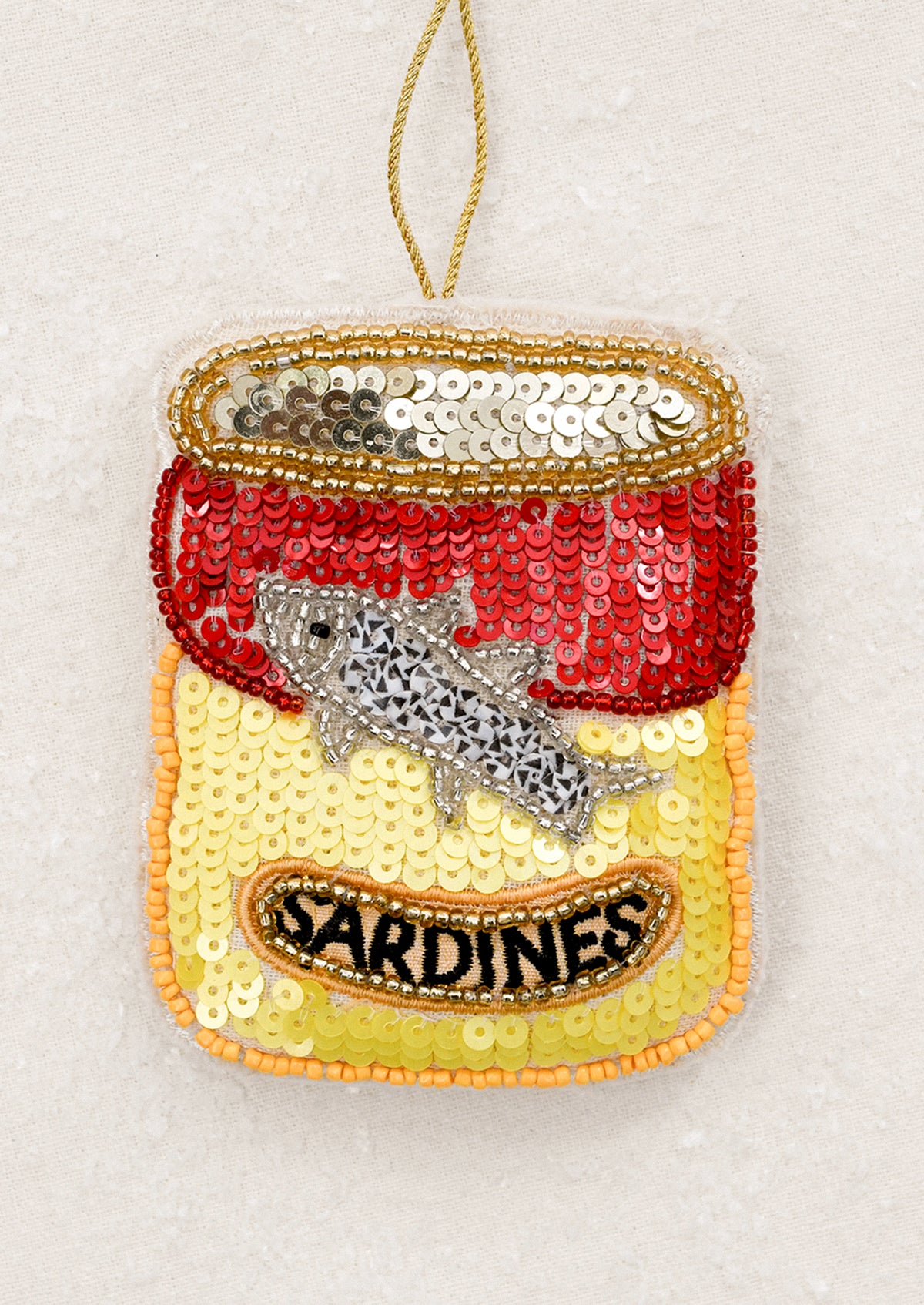 Sequined sardine can ornament with a fish.