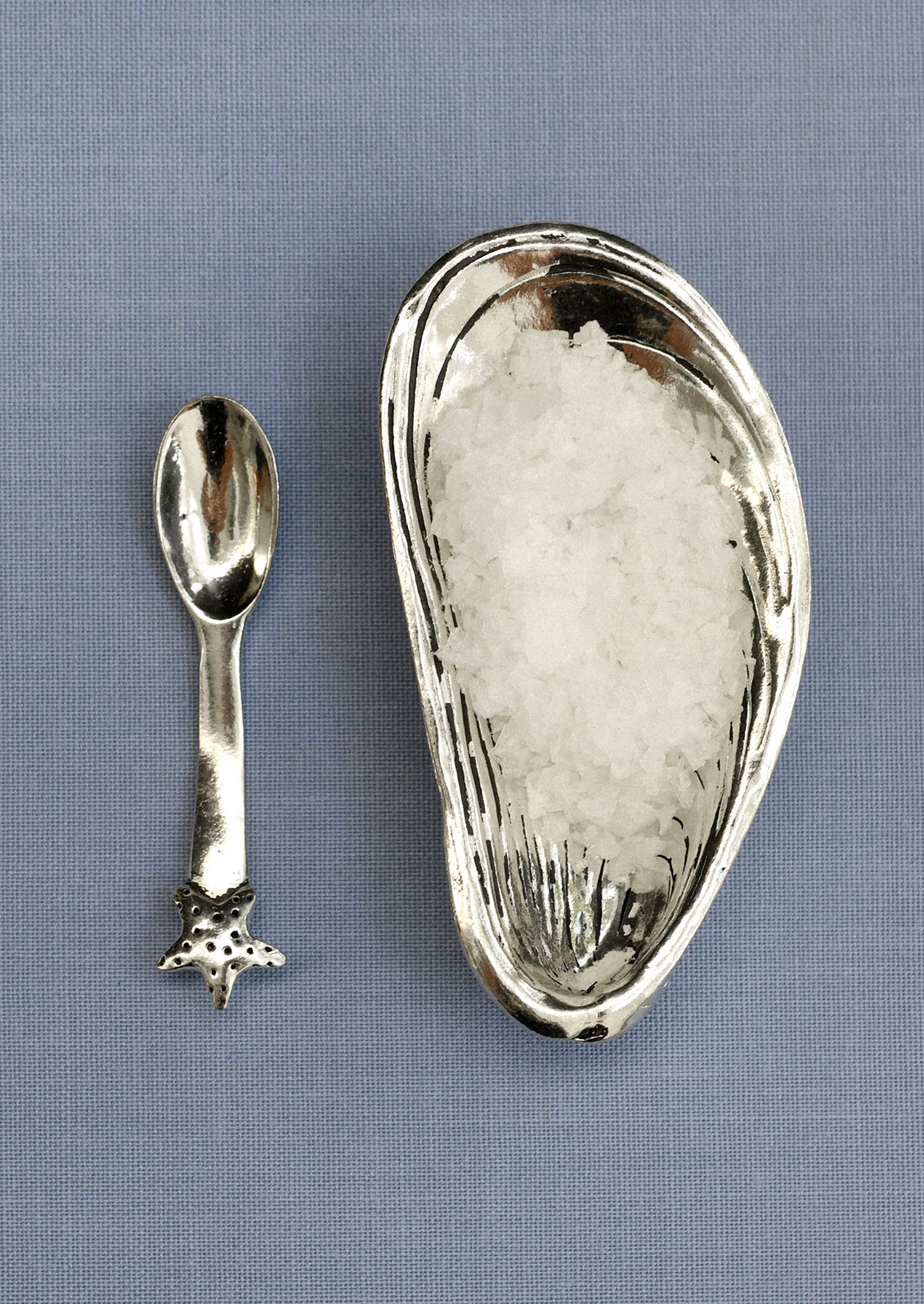 Silver mussel shaped salt cellar with a coordinating starfish spoon.
