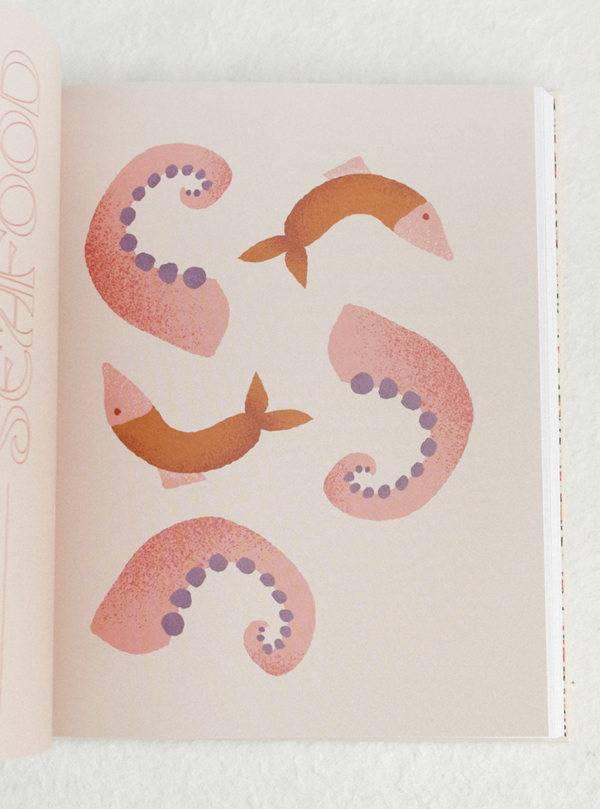Decorative paper with pink and orange fish designs on a light background