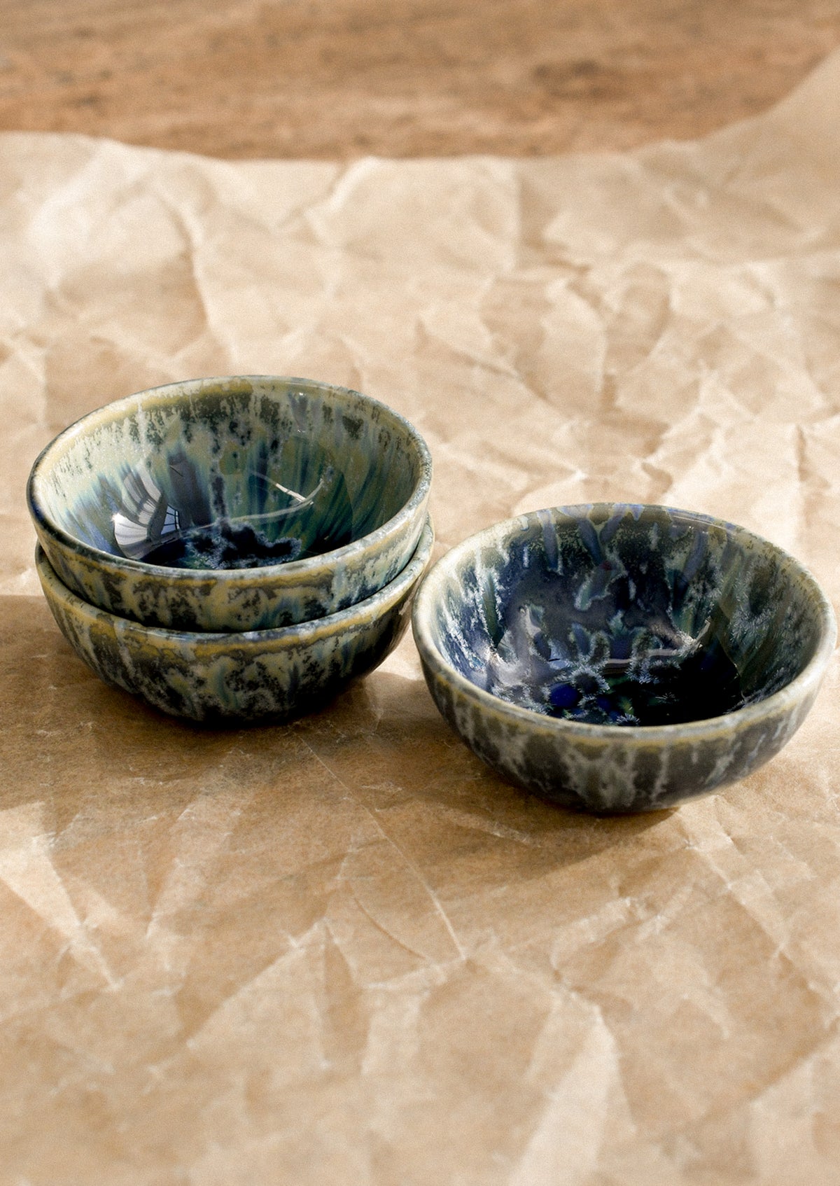 Three blue ceramic bowls on brown paper