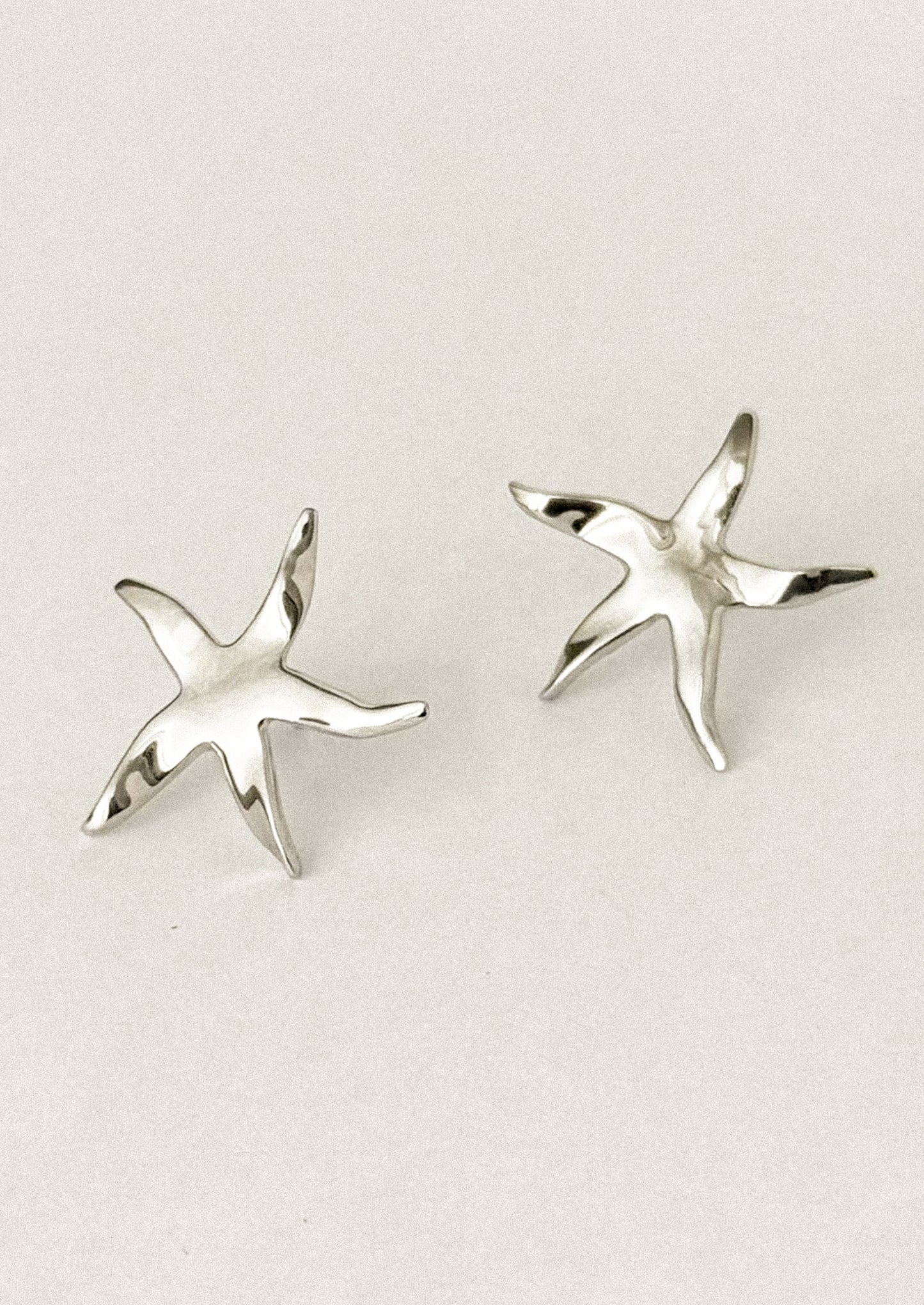 A pair of stud earrings in the shape of a whimsical, slightly asymmetrical star.