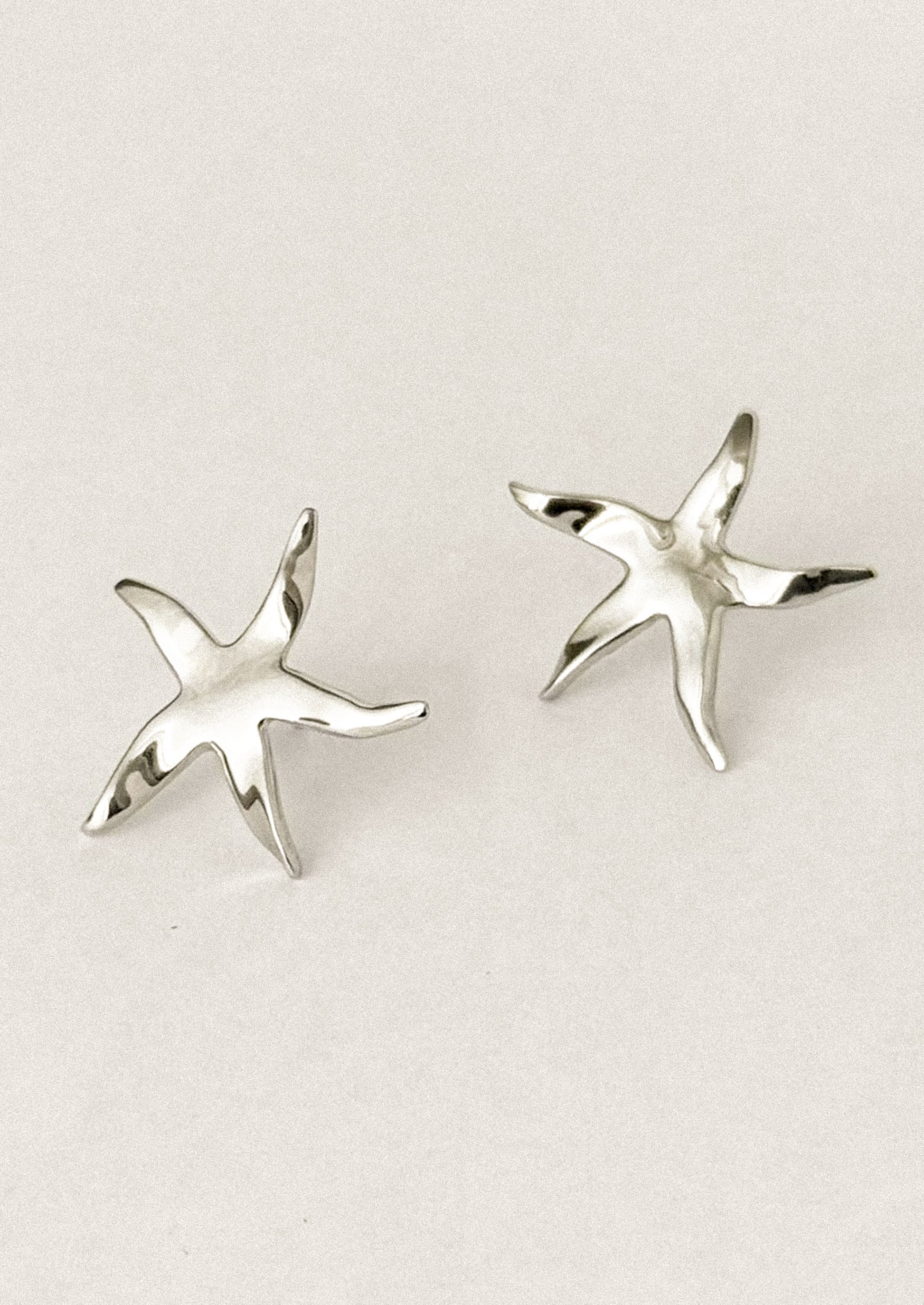 A pair of stud earrings in the shape of a whimsical, slightly asymmetrical star.