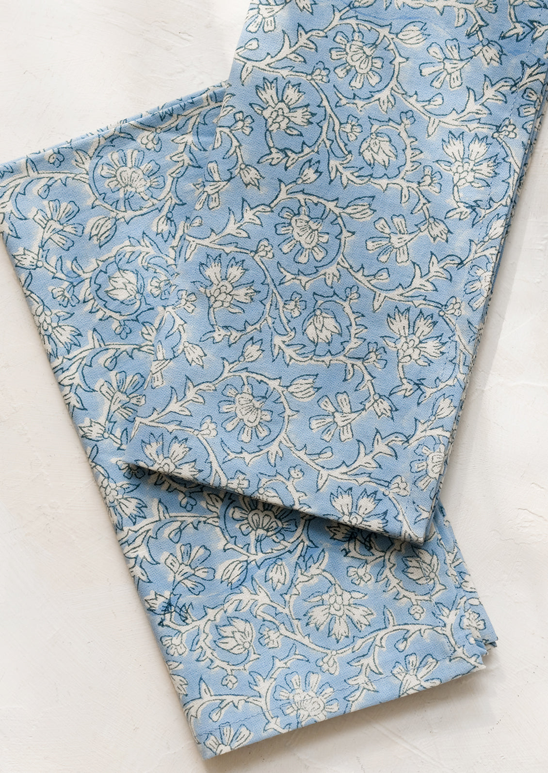 A pair of blue and white colored napkins with floral print.