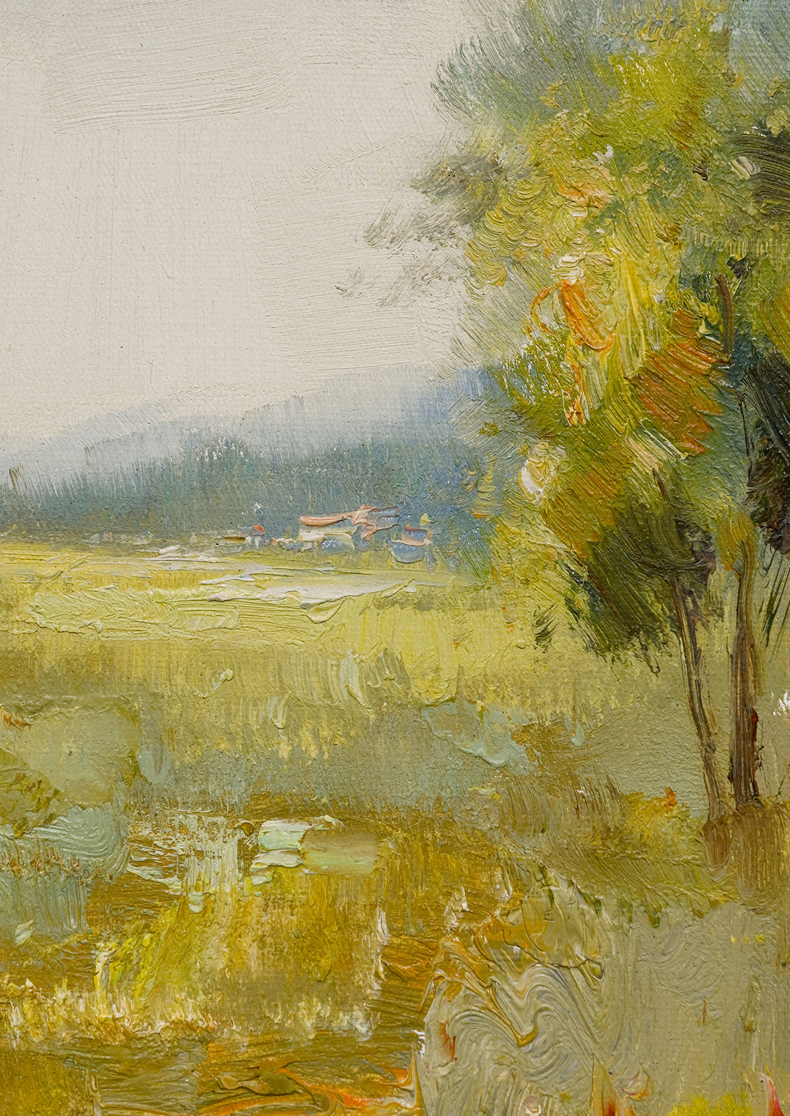 A framed oil landscape painting of a yellow-green meadow.