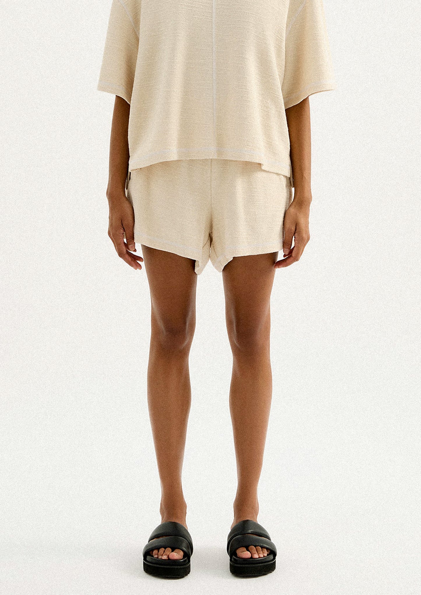 A pair of cream shorts in slub fabric with elasticized waistband.