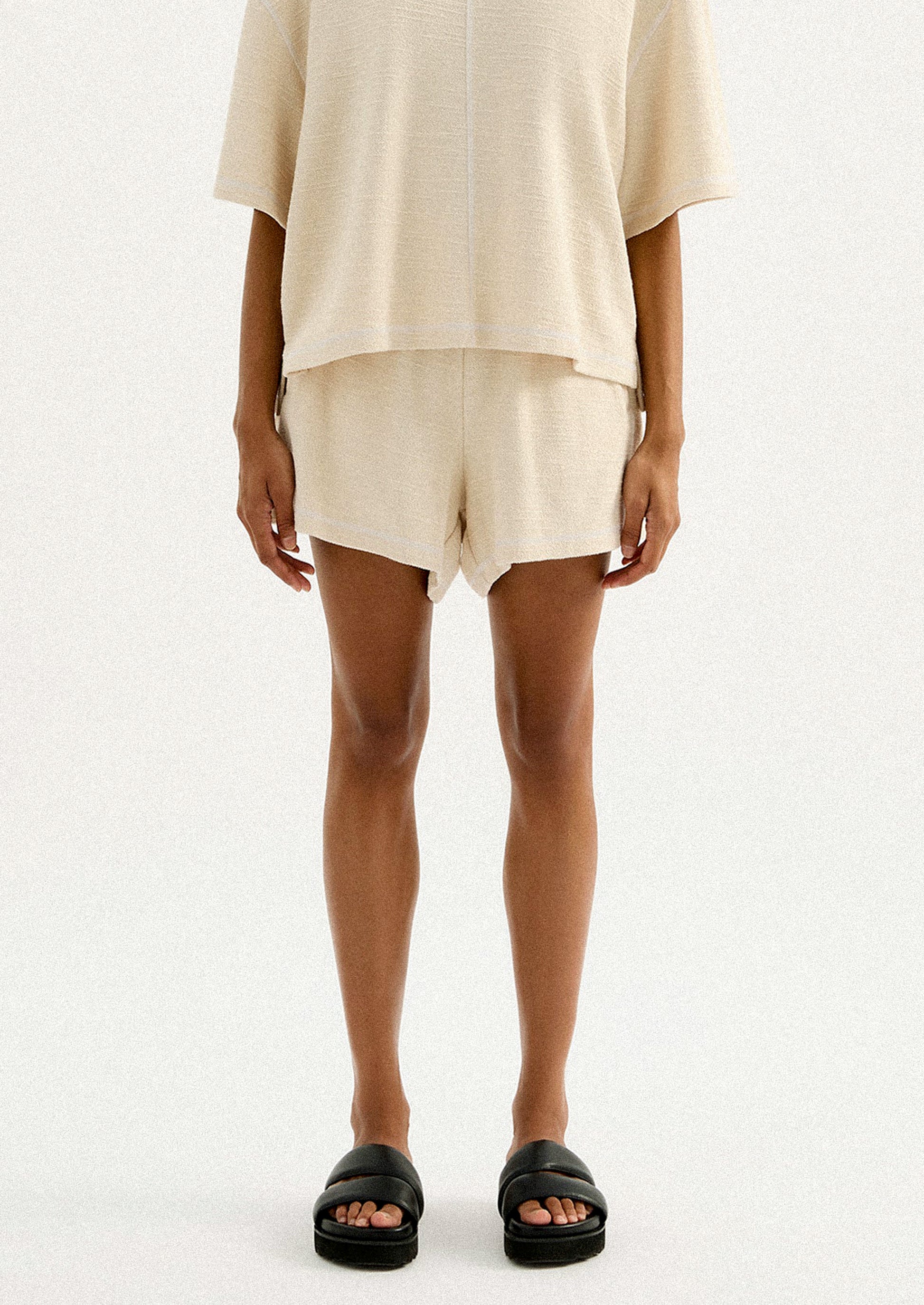 A pair of cream shorts in slub fabric with elasticized waistband.