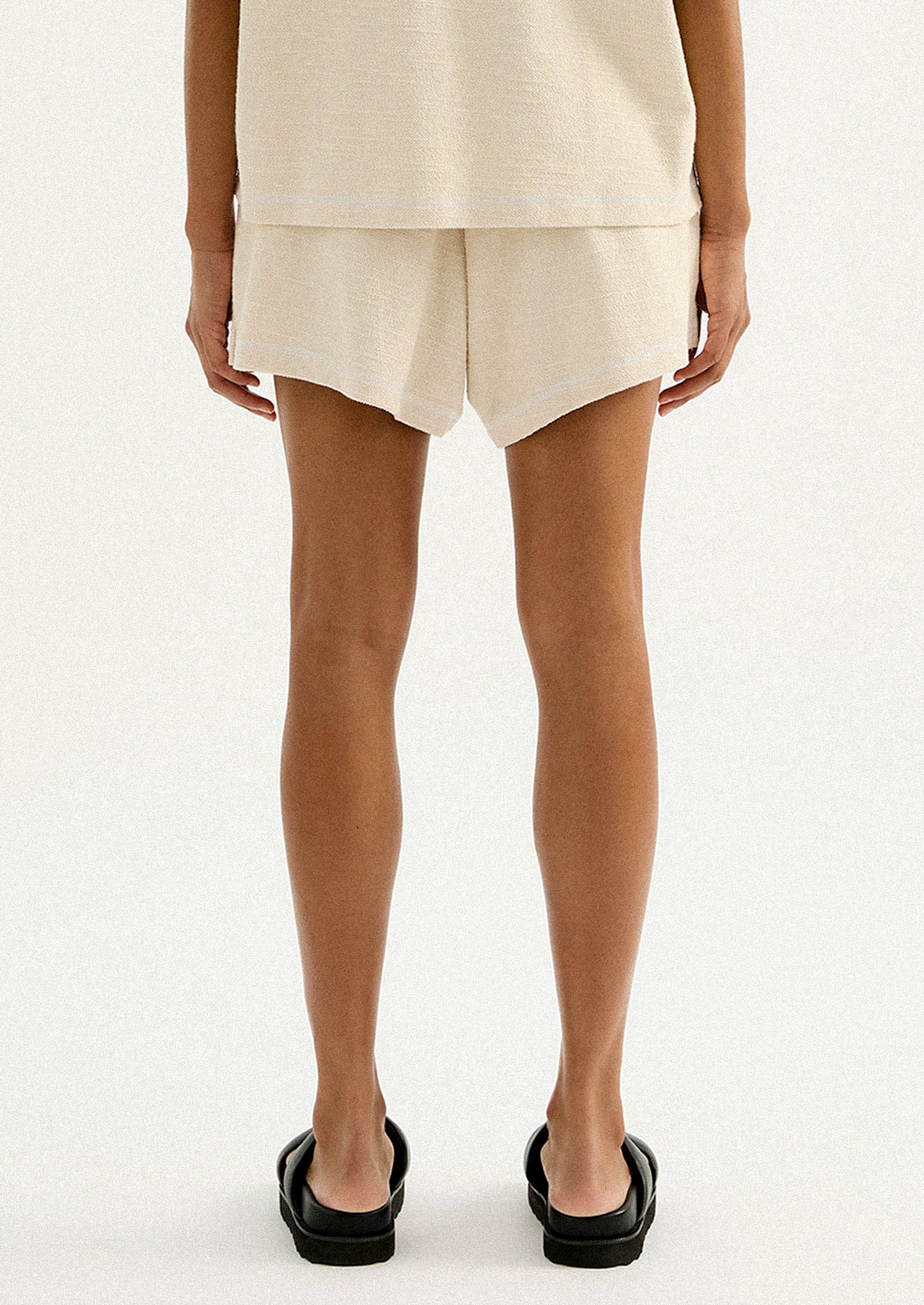 A pair of cream shorts in slub fabric with elasticized waistband.