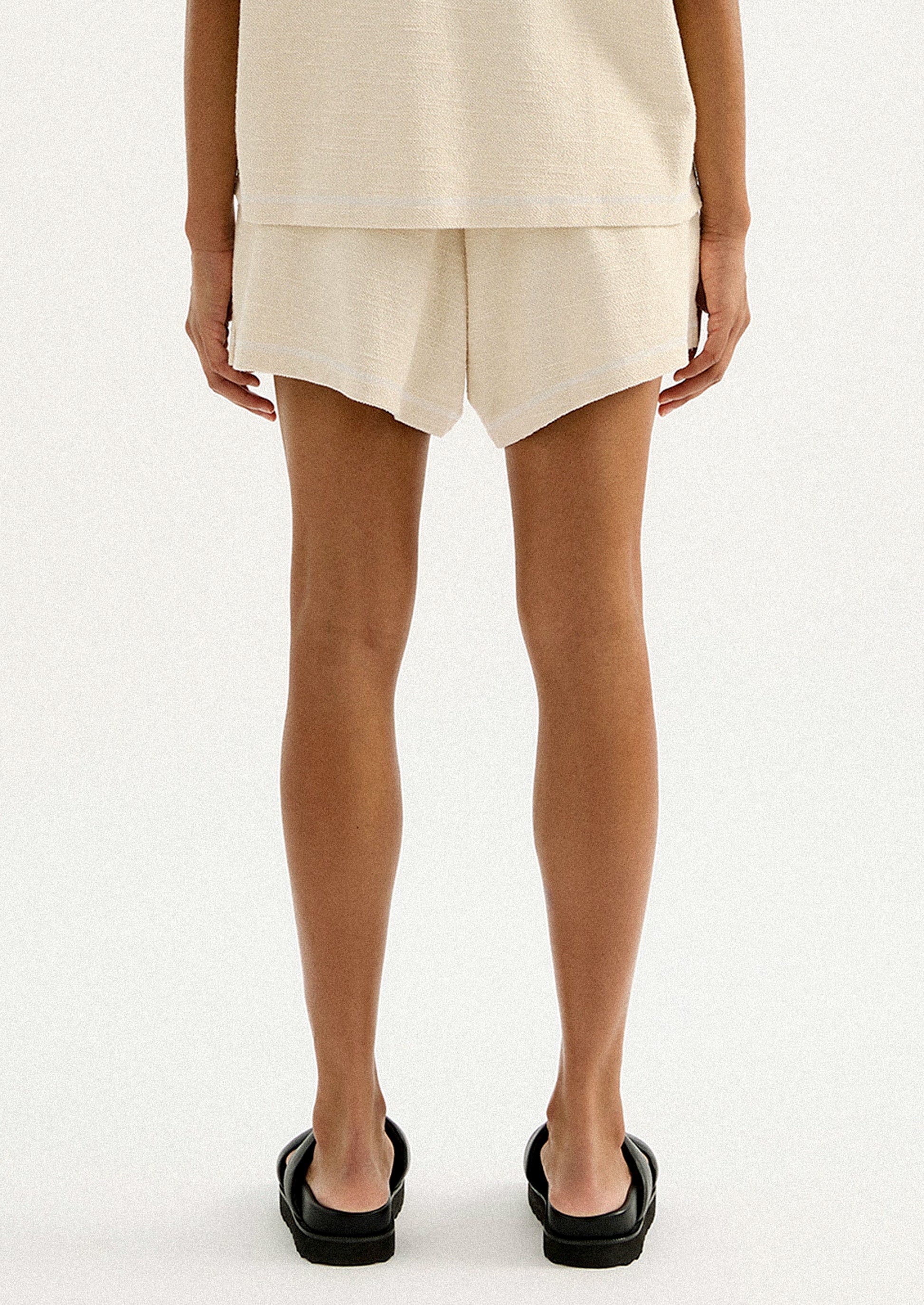 A pair of cream shorts in slub fabric with elasticized waistband.