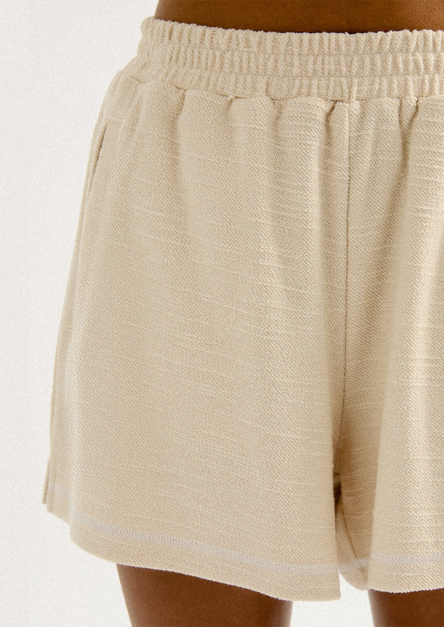 A pair of cream shorts in slub fabric with elasticized waistband.