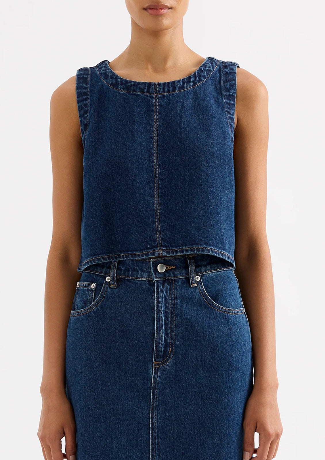 A woman wearing a shift top in dark denim rinse.
