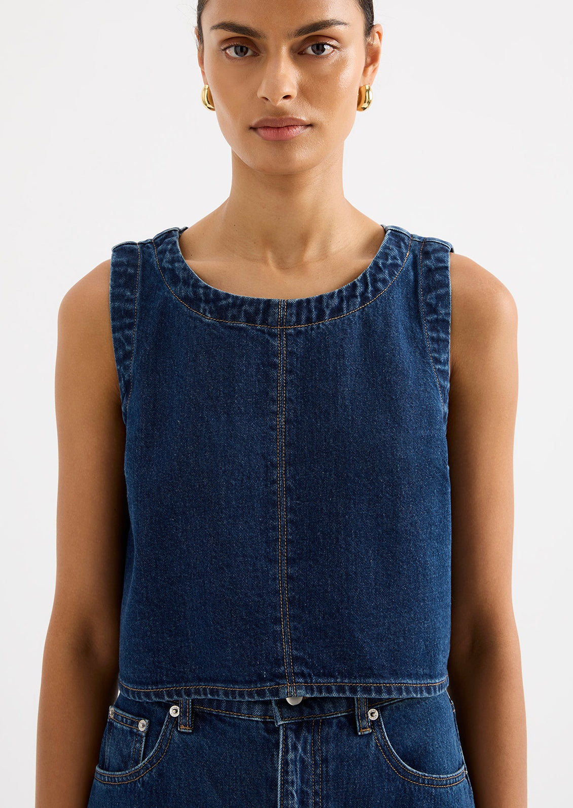 A woman wearing a shift top in dark denim rinse.