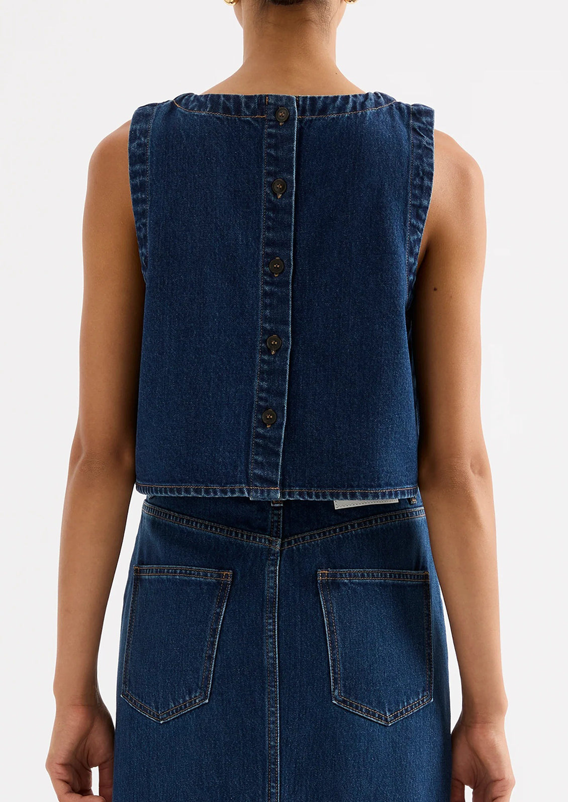 A woman wearing a shift top in dark denim rinse.