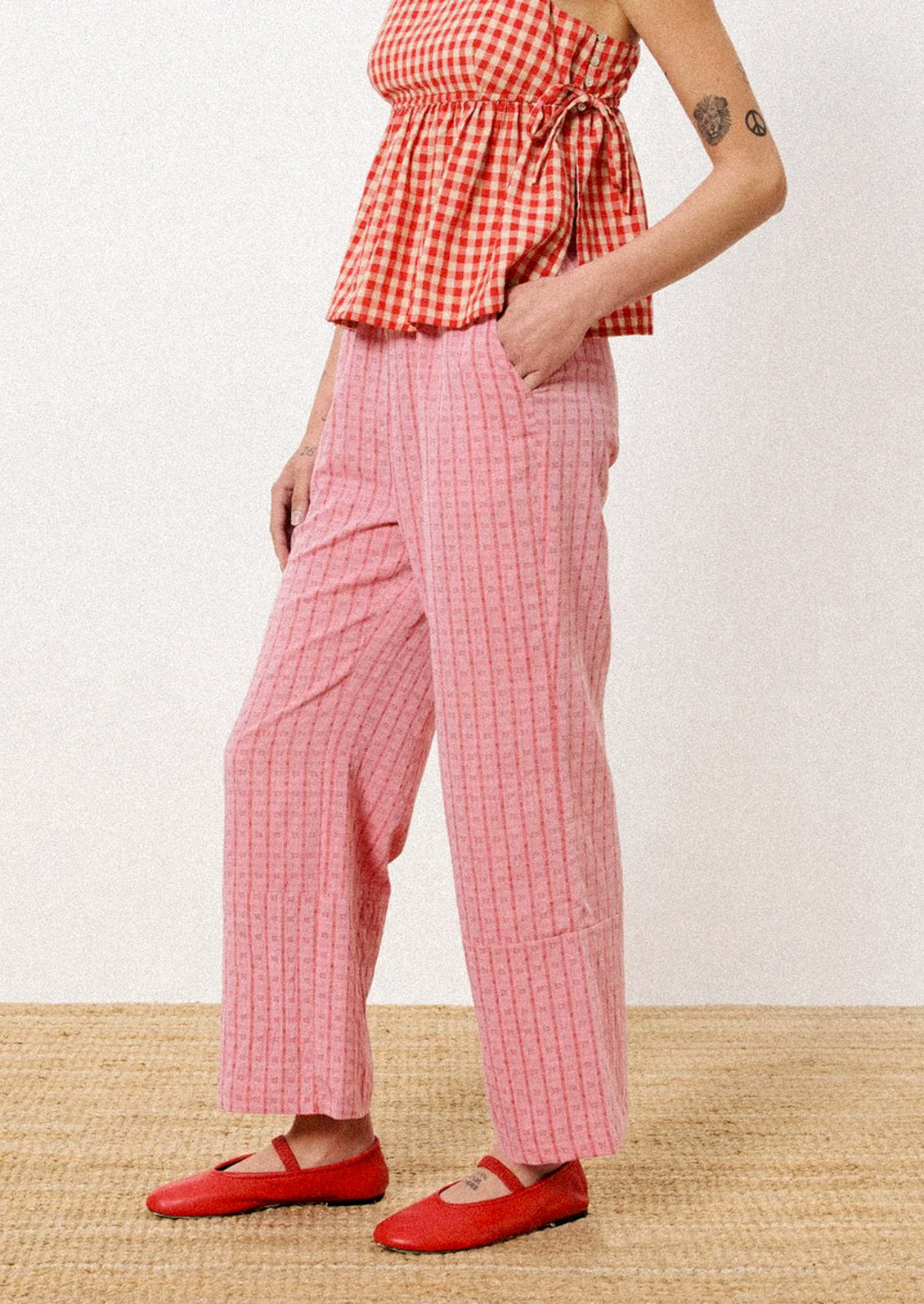A pair of pants in red jacquard check pattern.