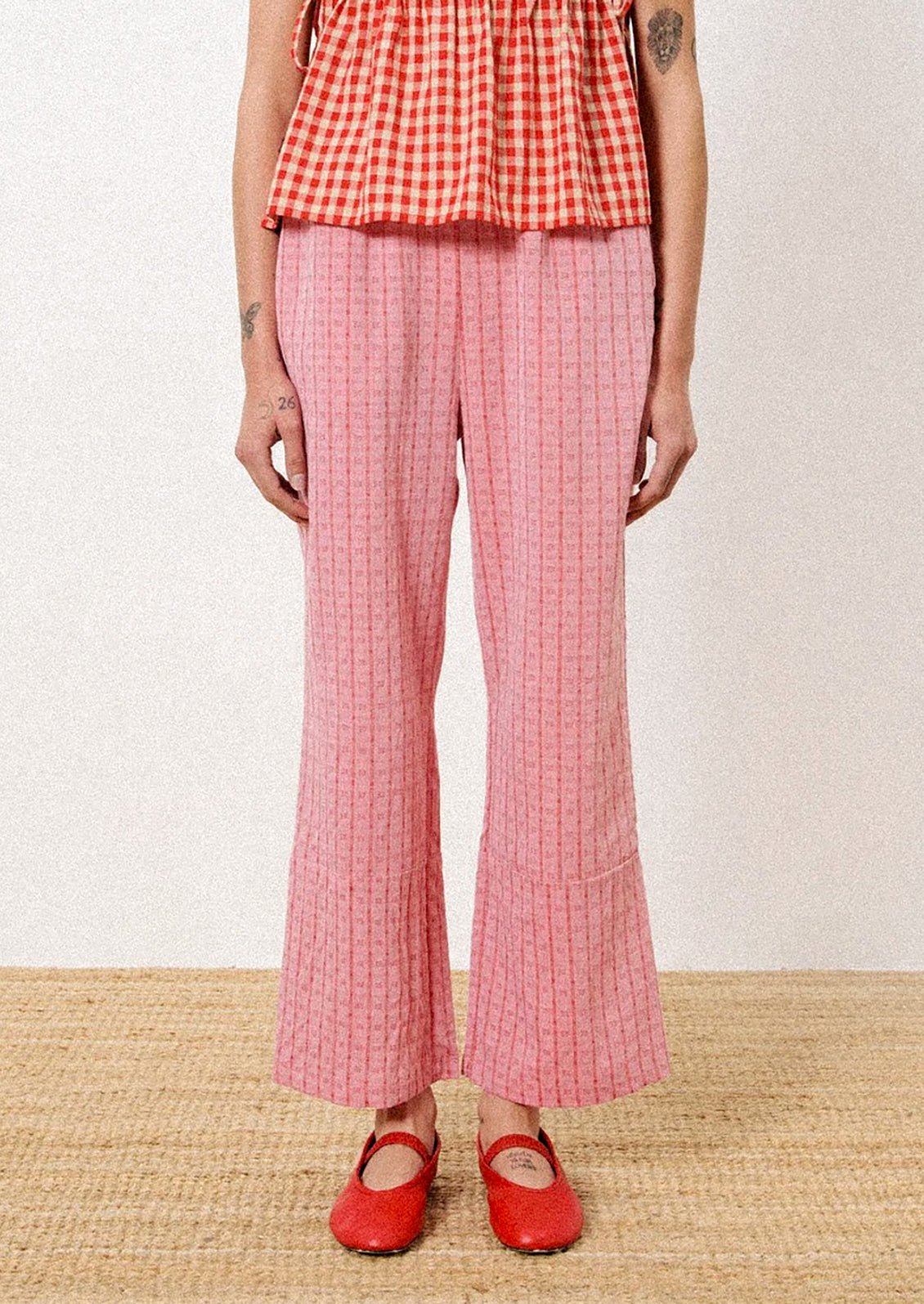 A pair of pants in red jacquard check pattern.