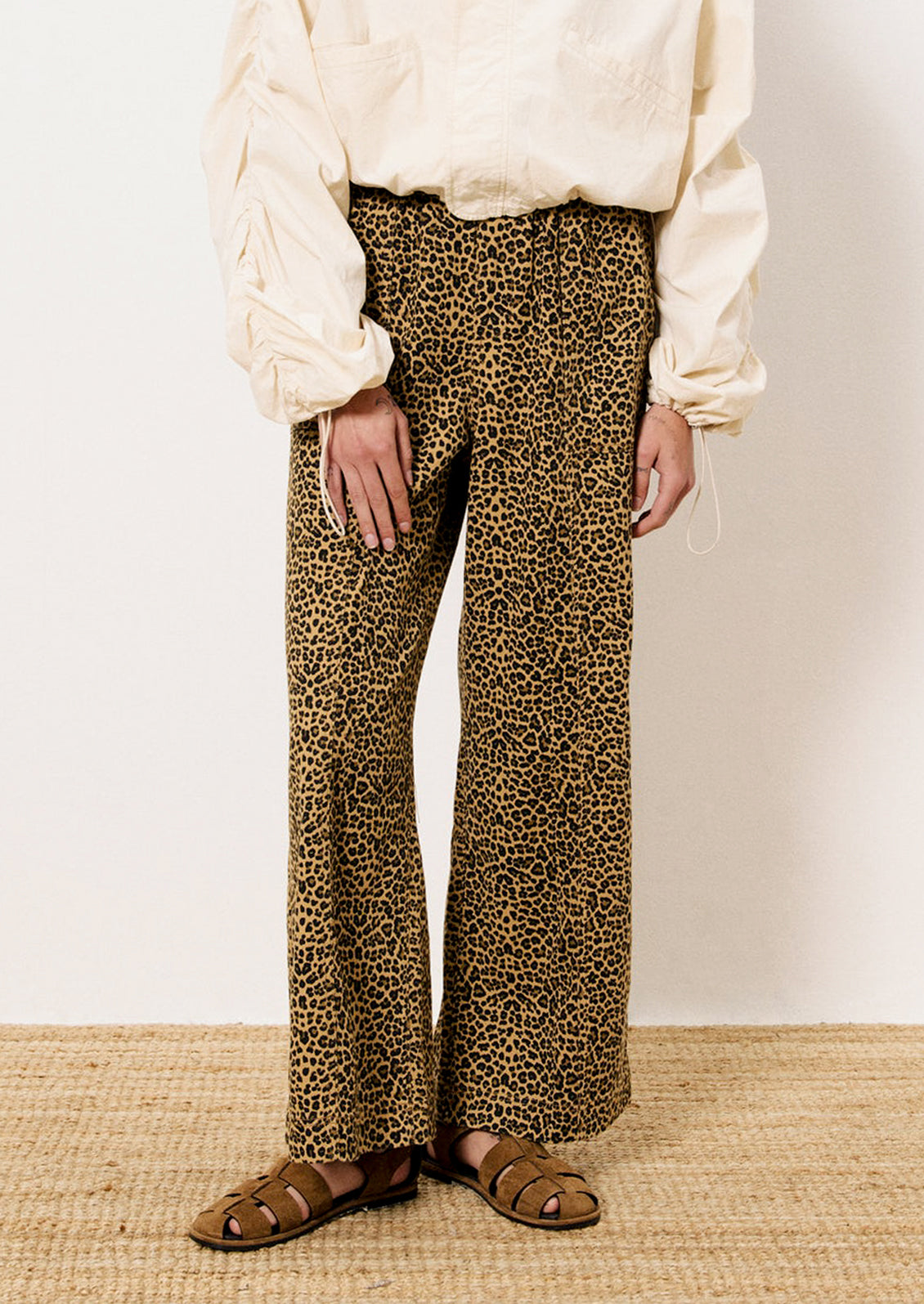 A person wearing a pair of leopard print pants with slightly wide leg.