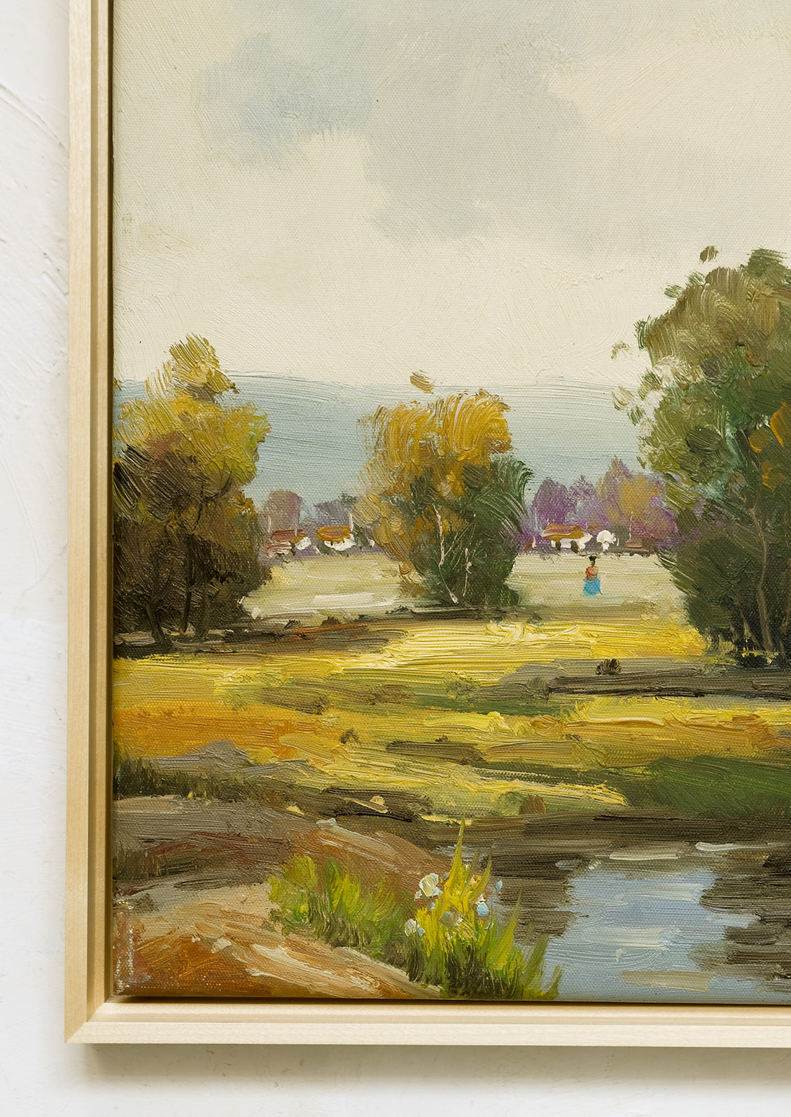 A framed oil landscape painting of trees near a pond.