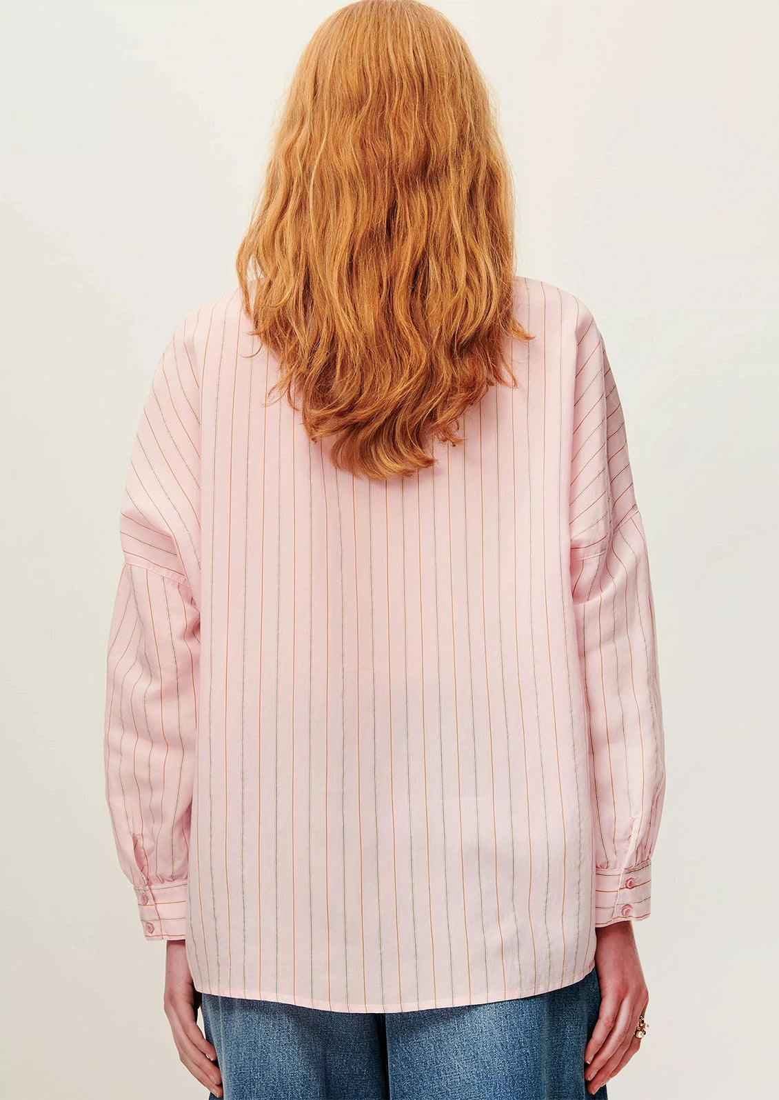 A button front shirt in pink with fine multicolor pinstripe pattern.