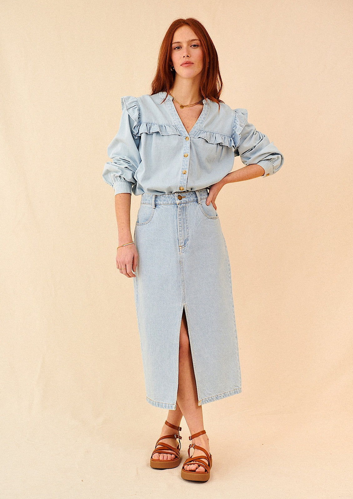 A woman standing wearing a midi length denim skirt and top