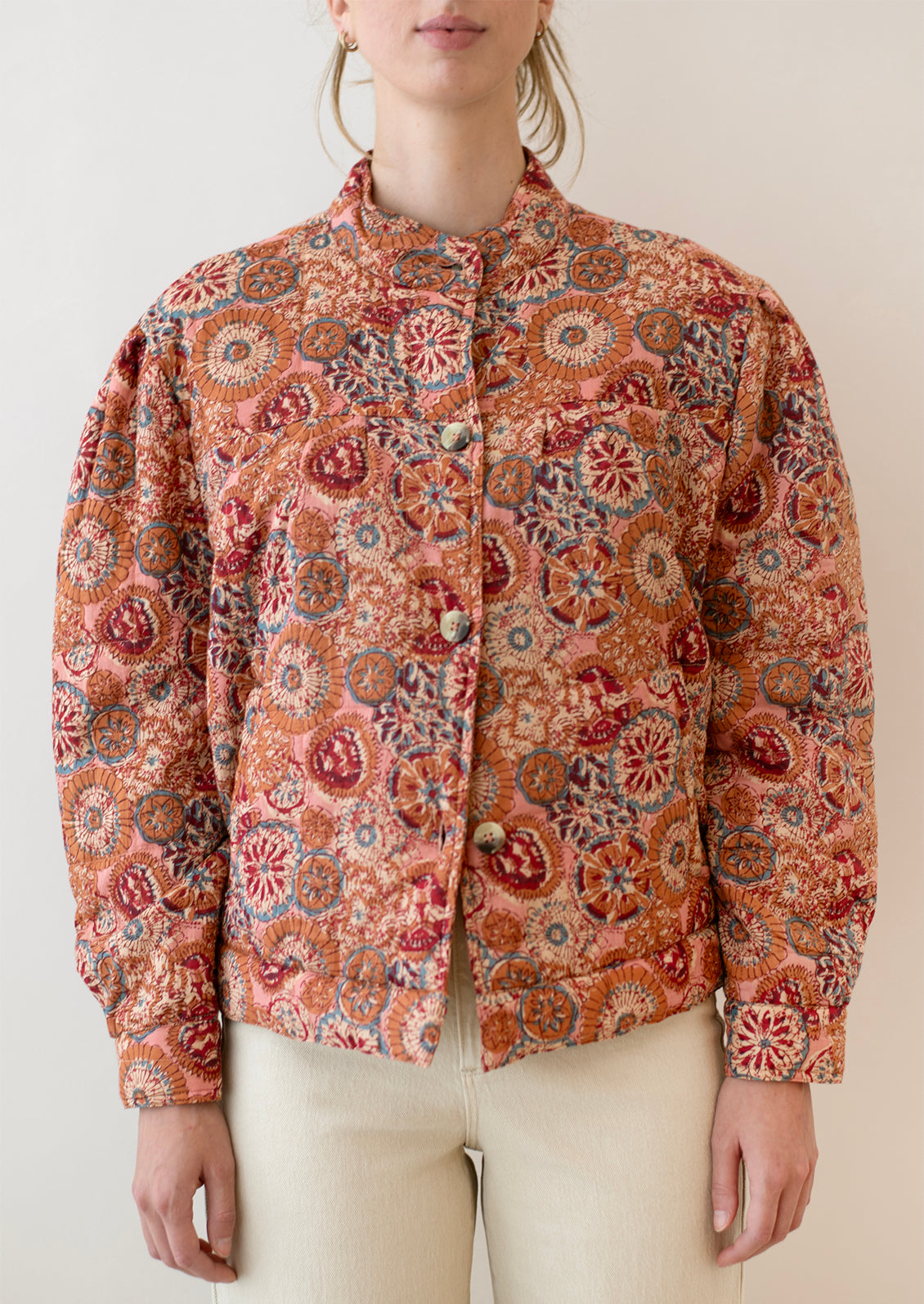A woman wearing a button front cotton jacket in multicolor kaleidoscope print.