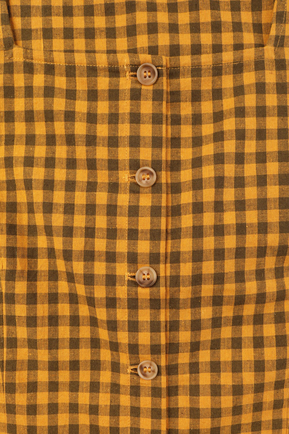 A short sleeve, square neck top in mustard and brown gingham.