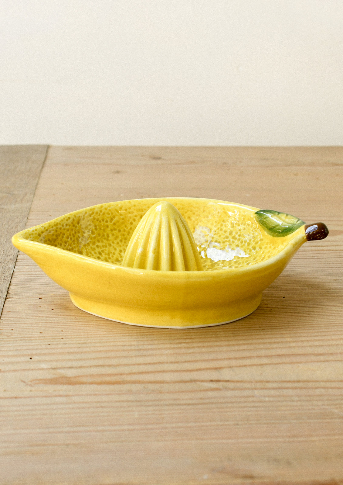A ceramic citrus juicer in the shape of a lemon.