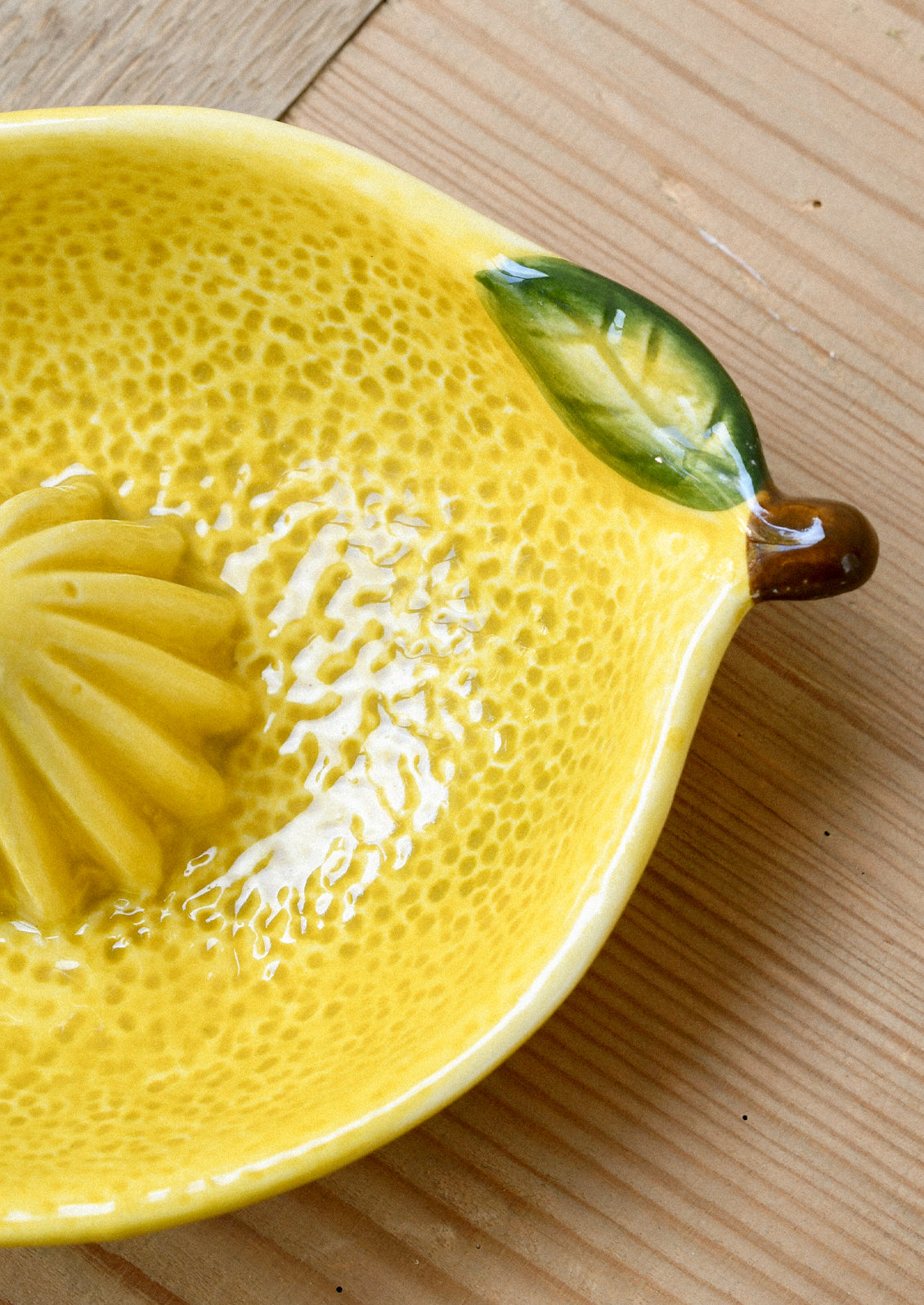 A ceramic citrus juicer in the shape of a lemon.