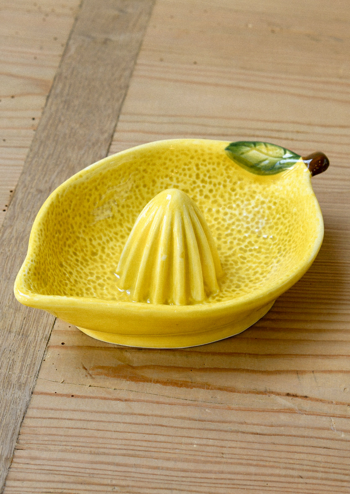 A ceramic citrus juicer in the shape of a lemon.