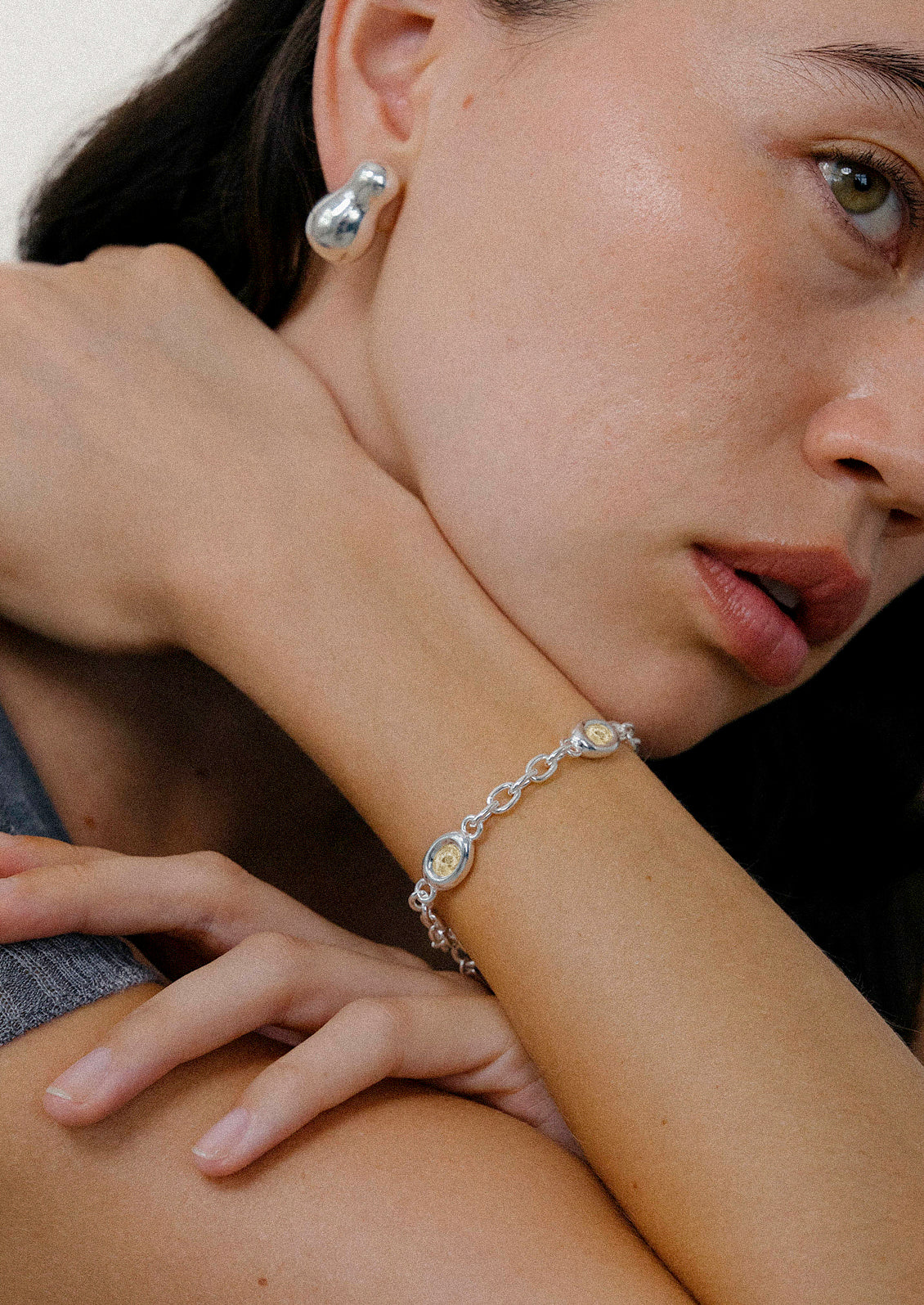 A sterling silver chain bracelet with yellow gems.