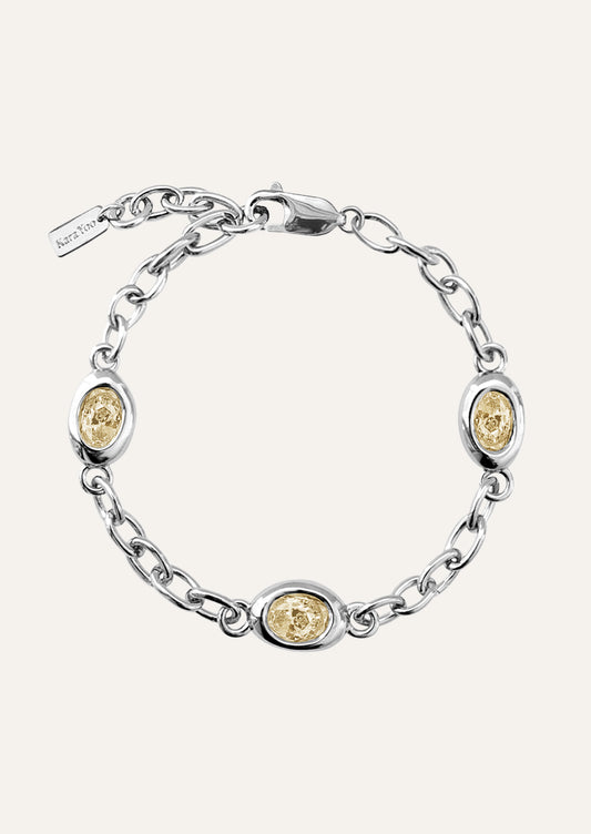 A sterling silver chain bracelet with yellow gems.