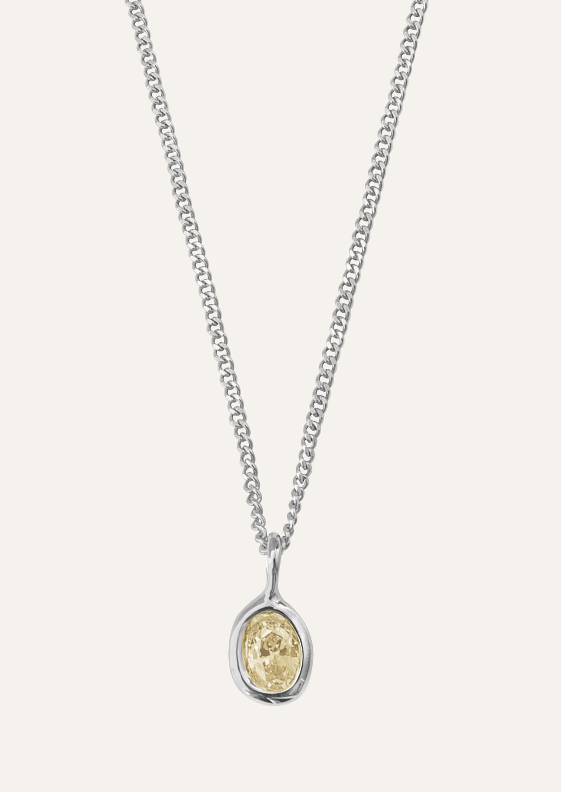 Silver necklace with an oval shaped pendant featuring a citrine colored gemstone.