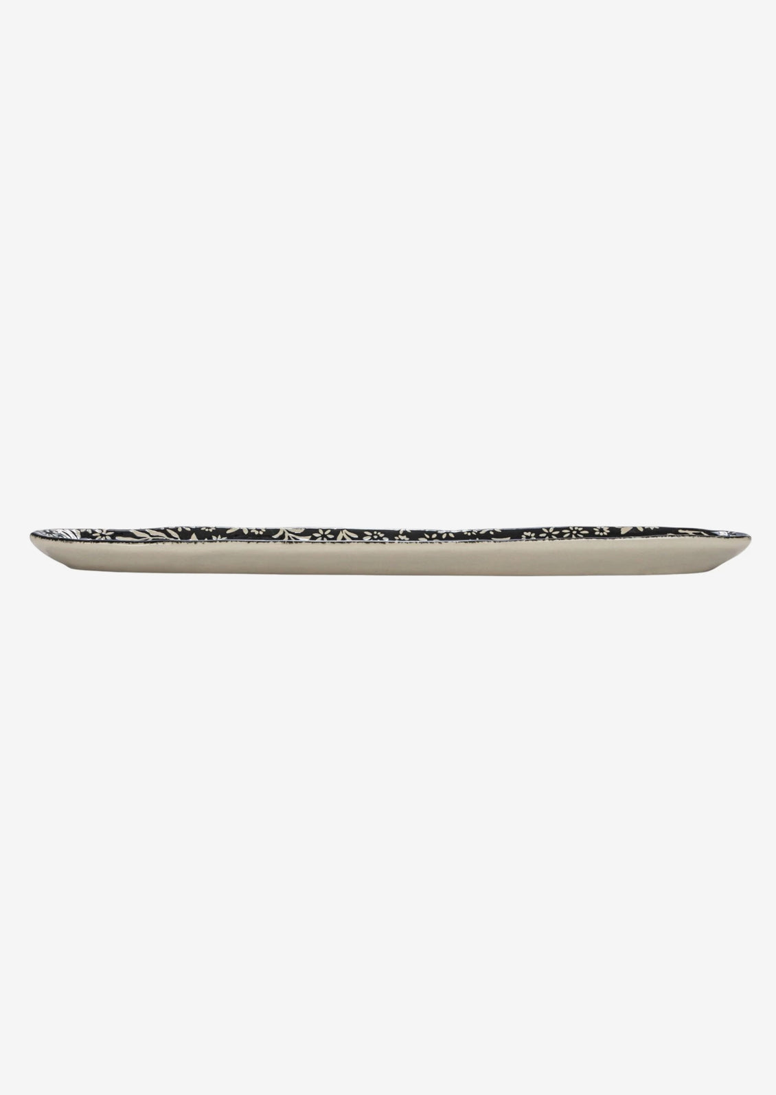 A slim, oval shaped ceramic tray in black with white botanical pattern.