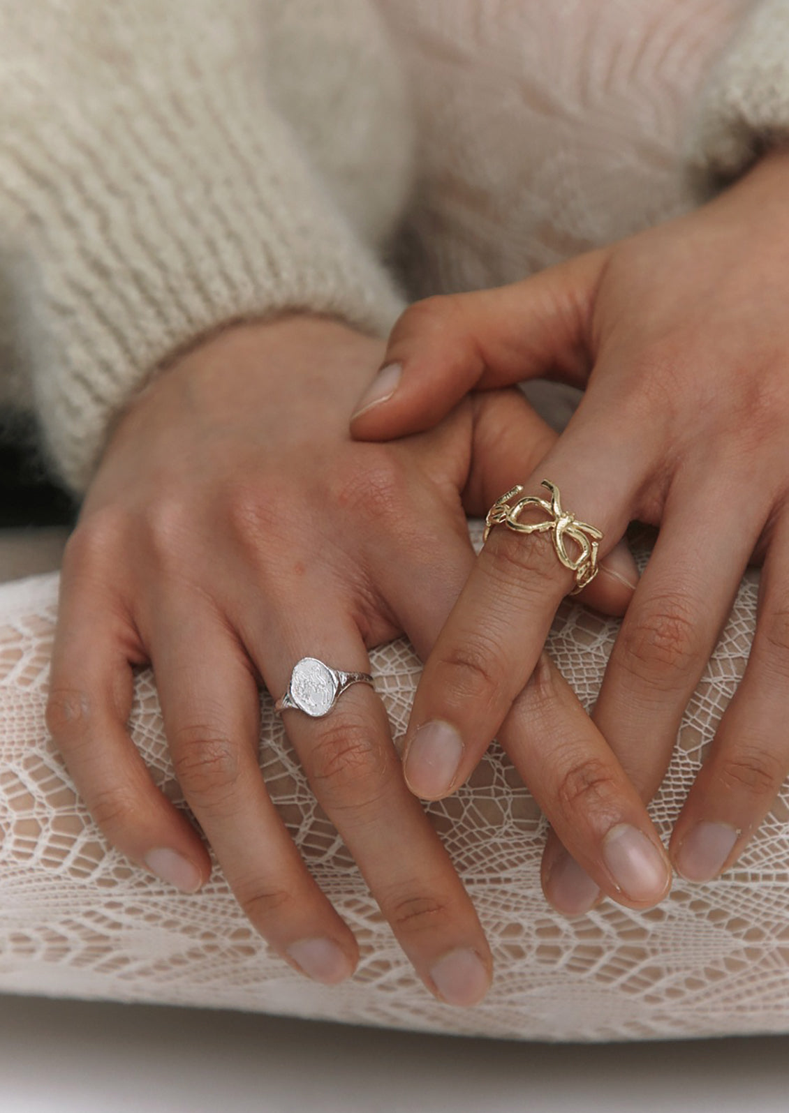 A woman wearing gold and silver bow themed rings.