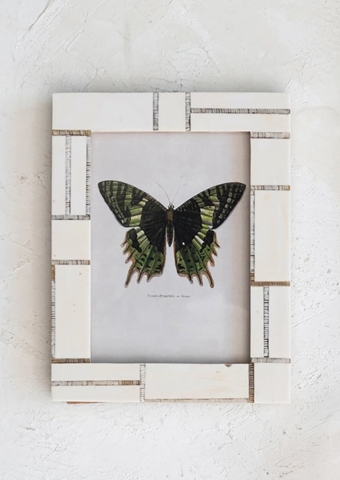 A cream picture frame with brown asymmetrical line design.