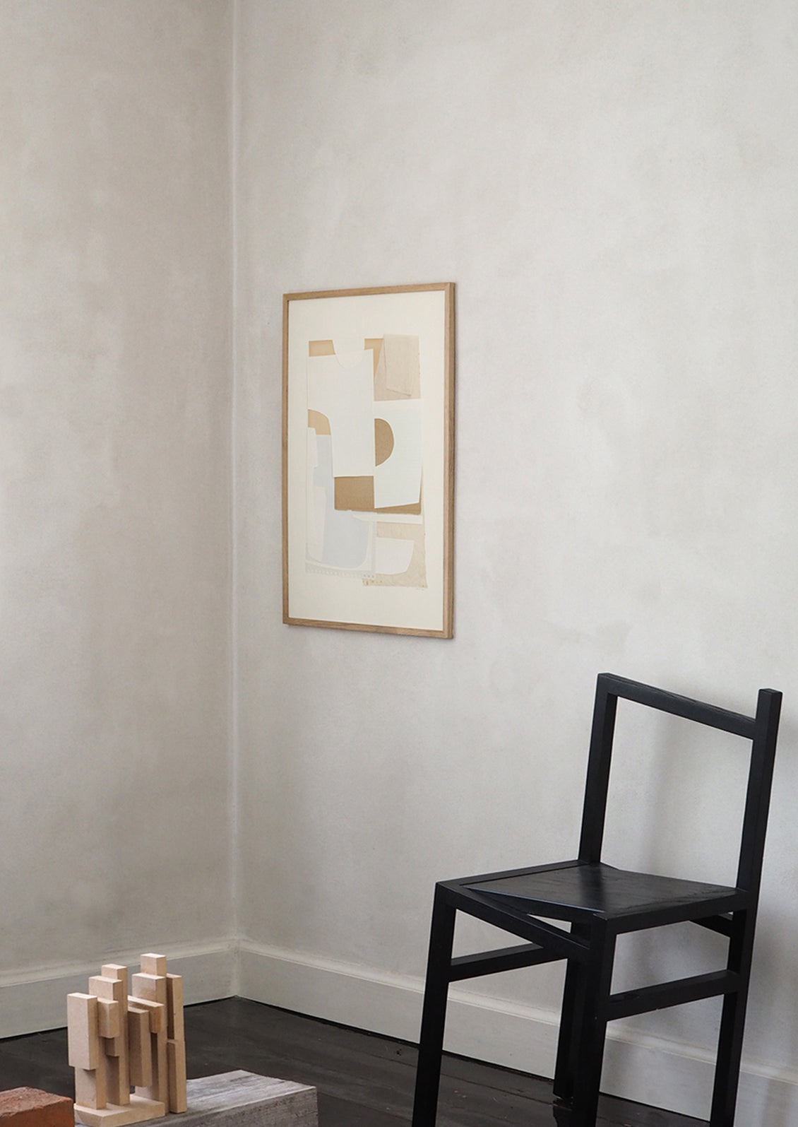 An abstract artwork with layers of cutout paper in neutral tones.