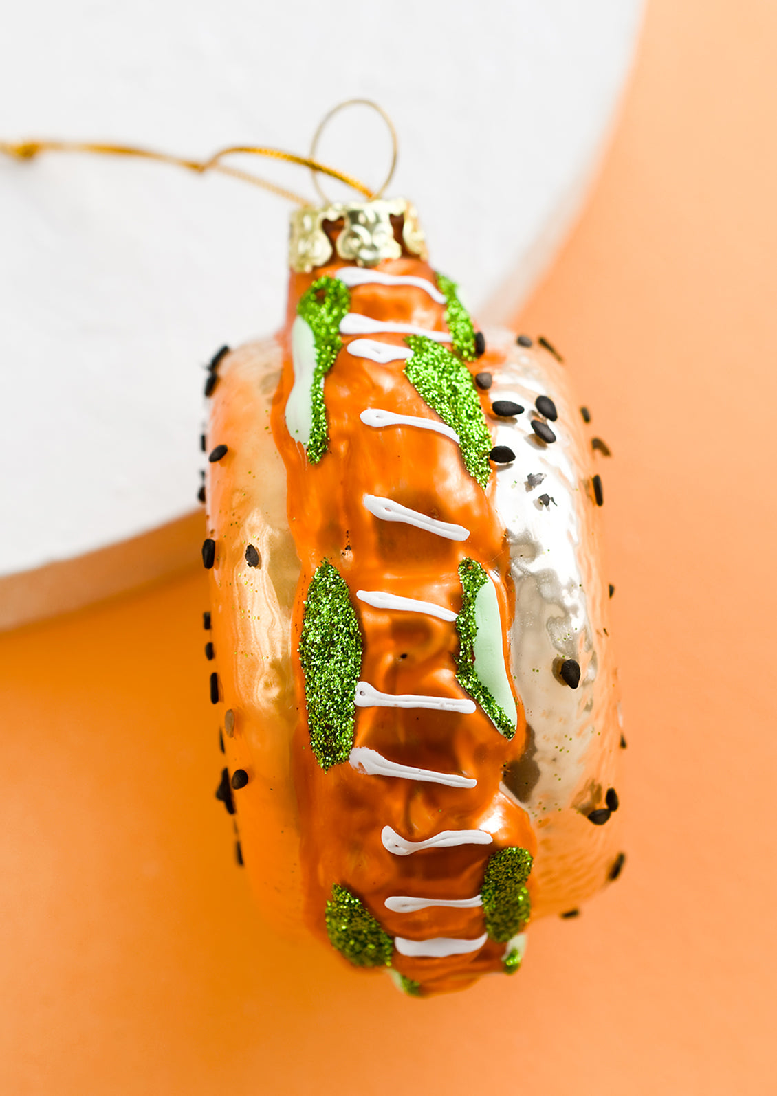 A glass ornament that looks like a bagel with lox.