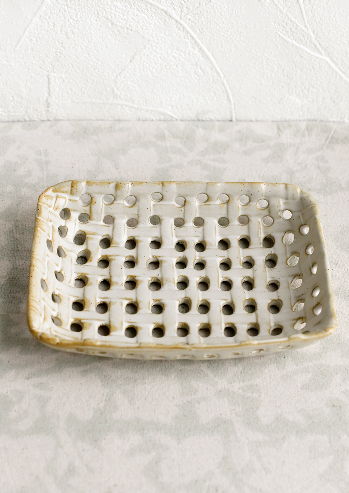 A rectangular shaped ceramic tray with open basketweave design.