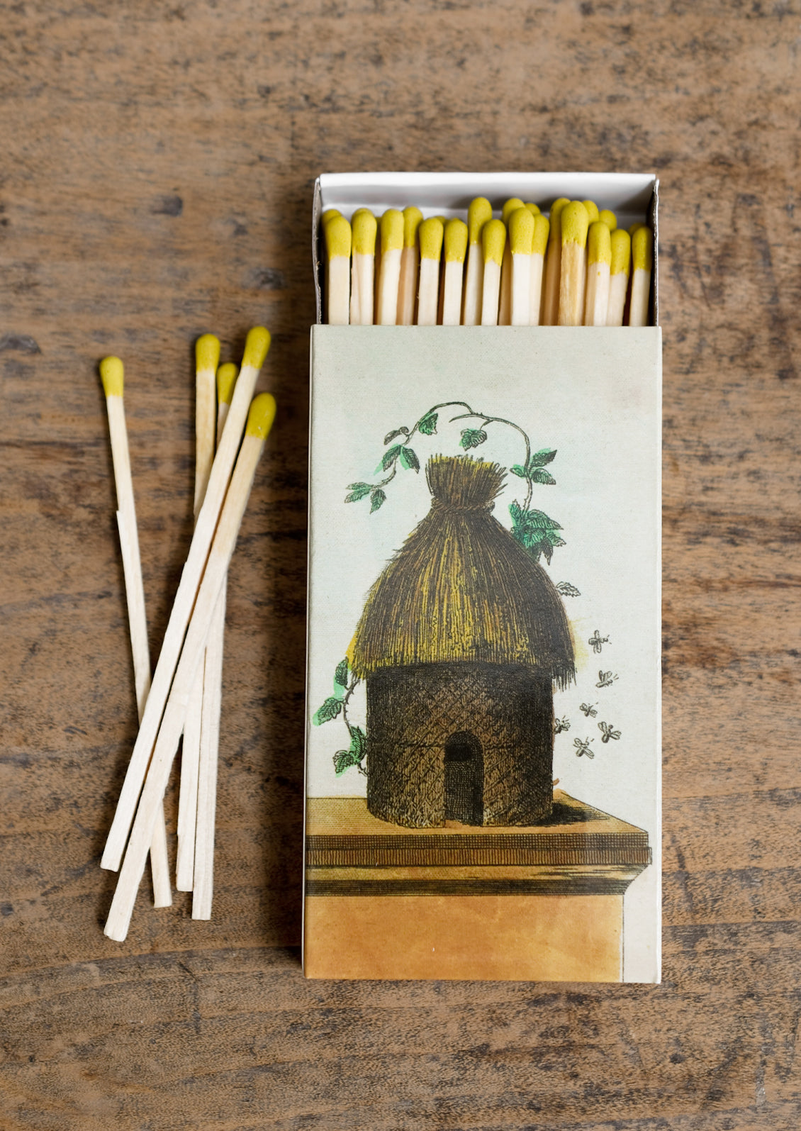 A box of yellow-tipped matches, box has vintage inspired beehive illustration.