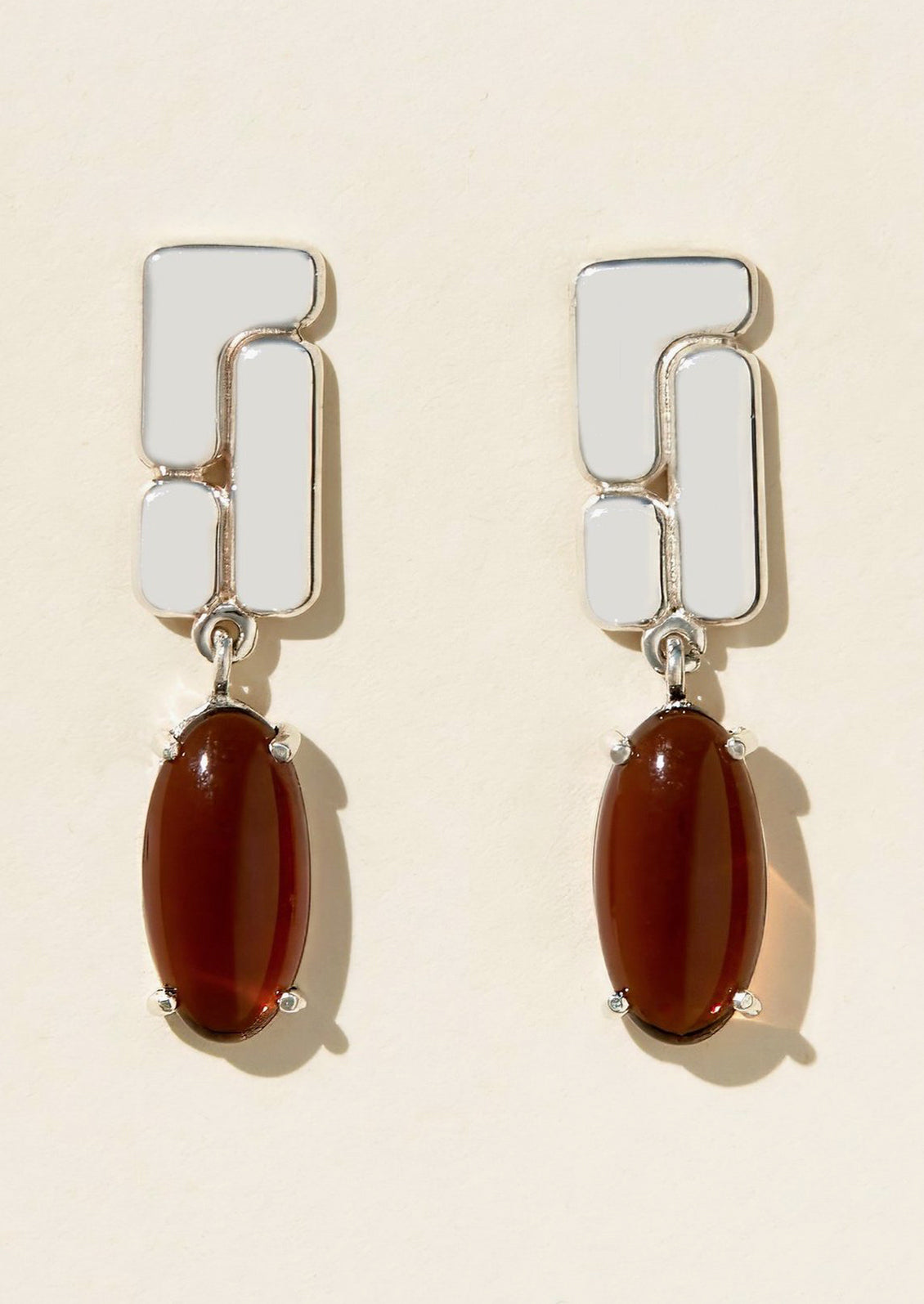 A pair of sterling silver drop earrings with brown glass cabochons.