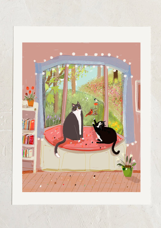 An art print of an illustration of two cats watching a bird feeder.