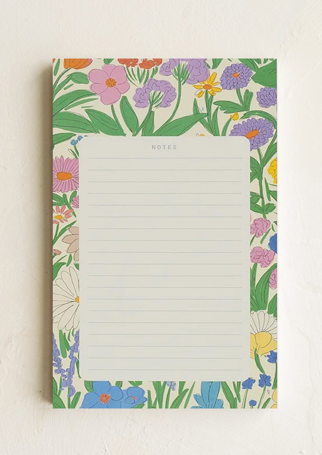 A ruled notepad with patterned background border in floral print.